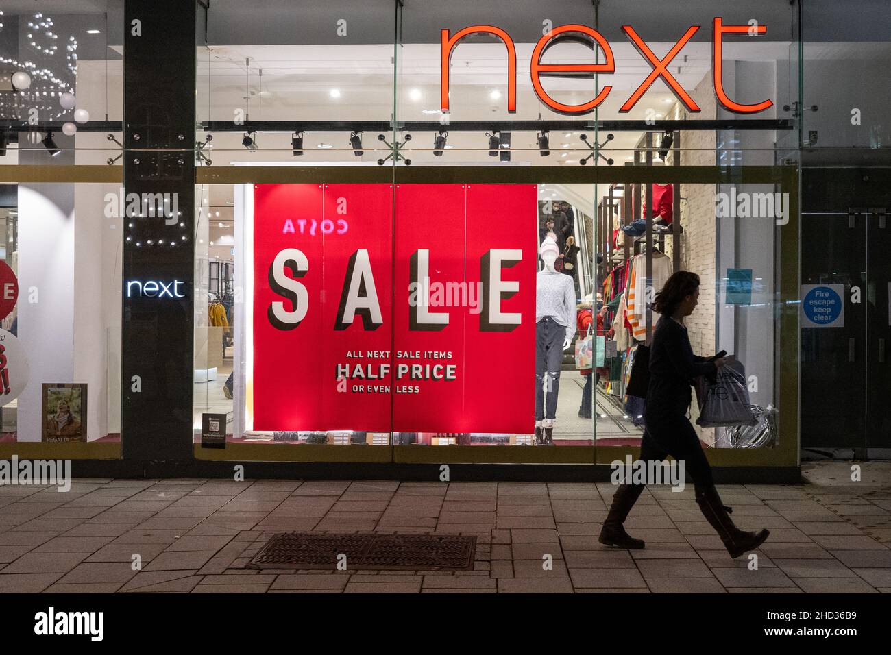 Une personne passe devant un magasin de détail Next à Cardiff, au pays de Galles, au Royaume-Uni. Banque D'Images