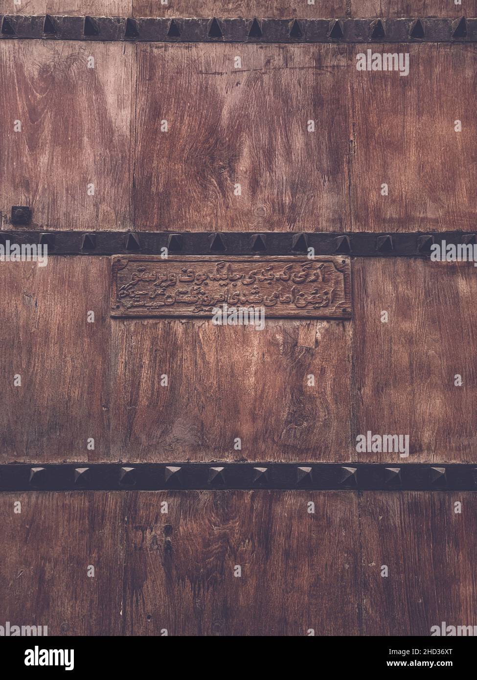 Photo panoramique d'une ancienne porte en bois sombre avec texte non reconnaissable gravé Banque D'Images