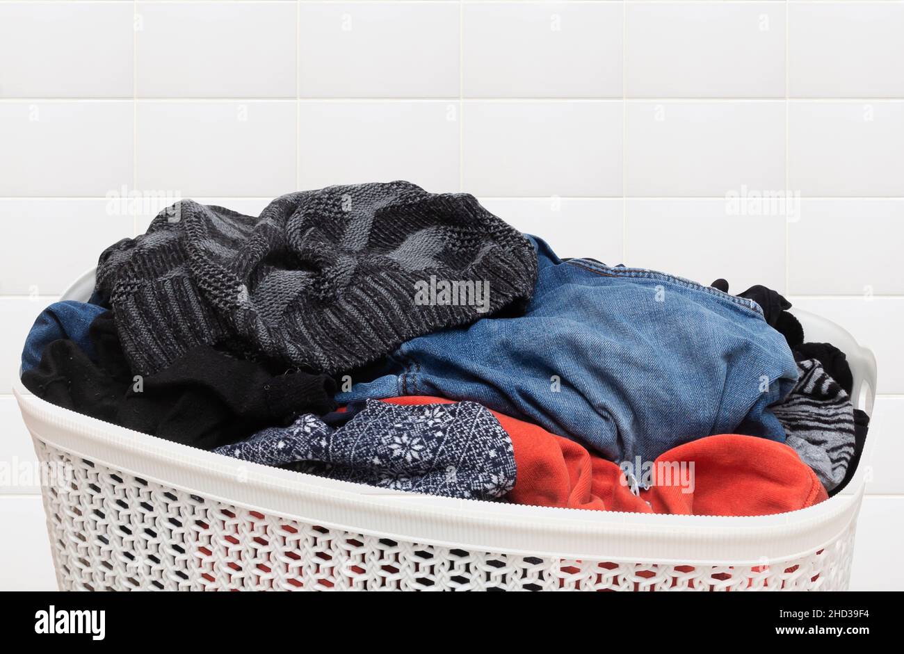 Vêtements dans un panier à linge en plastique sur fond isolé Banque D'Images