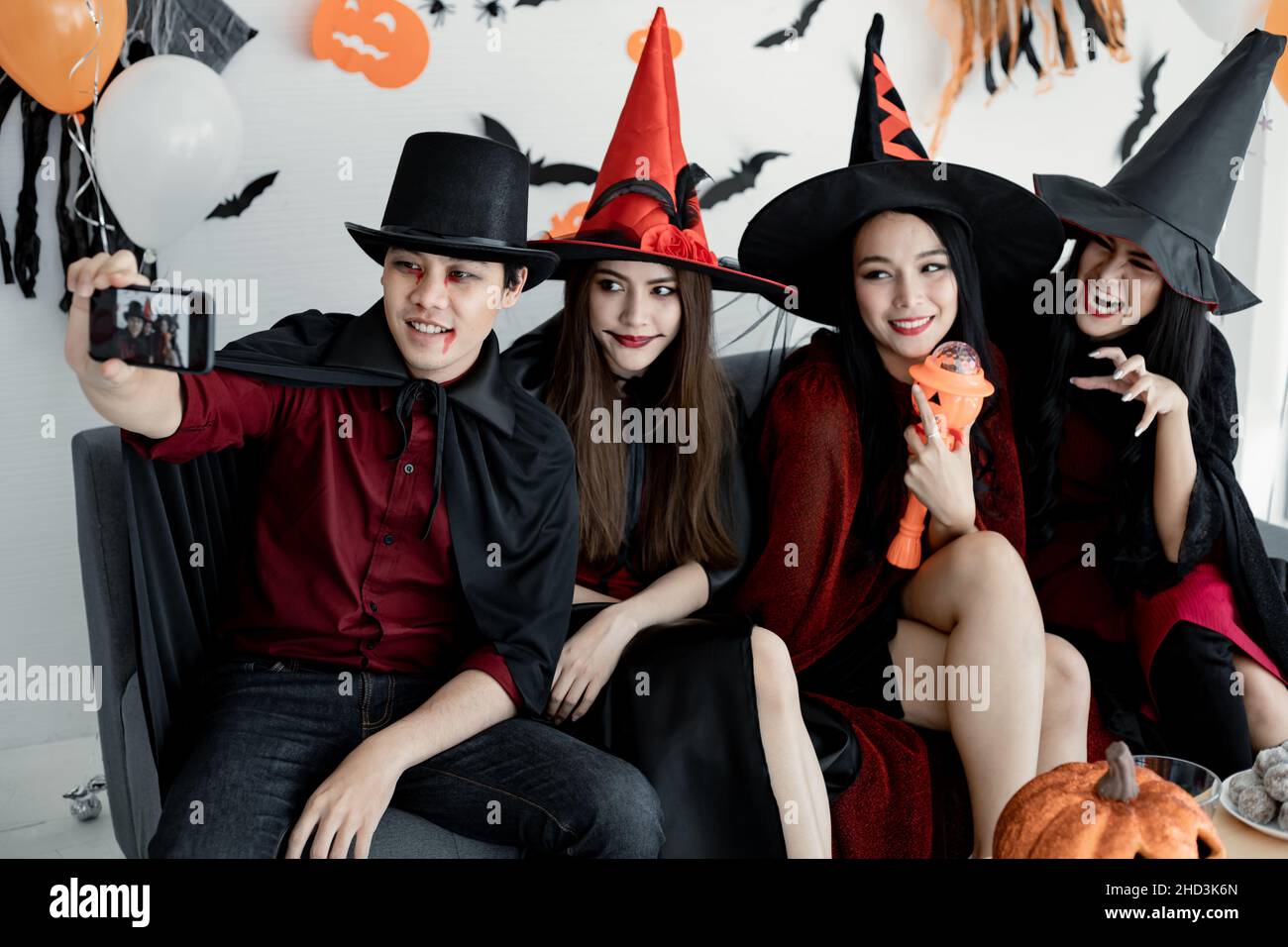 Regroupez les jeunes asiatiques en sorcière déguisée, assistant fêtez la fête et le selfie dans la salle avec thème Halloween.Gang Teen Thai avec fête de fête d'Halloween Banque D'Images