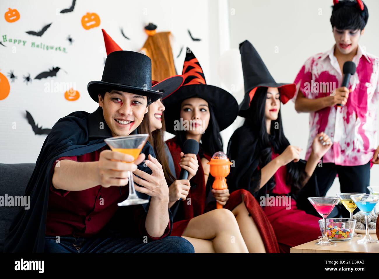 Regroupez les jeunes asiatiques en sorcière déguisée, assistant fêtez la fête avec un verre dans la salle pour le thème Halloween.Gang Teen Thai avec fête d'Halloween fête W Banque D'Images