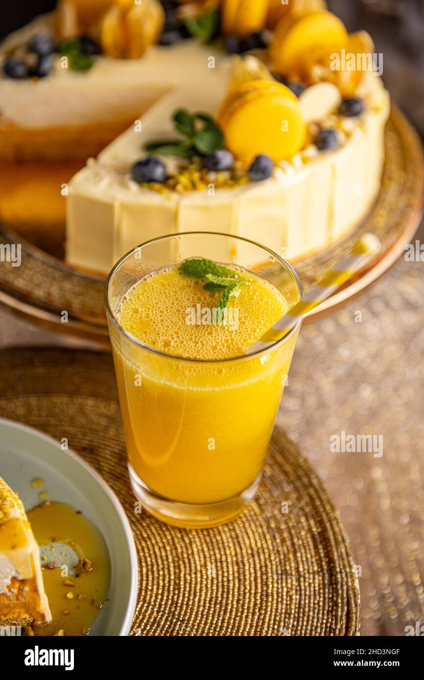 Un verre de jus d'orange se trouve près d'un gâteau dans la boulangerie Banque D'Images