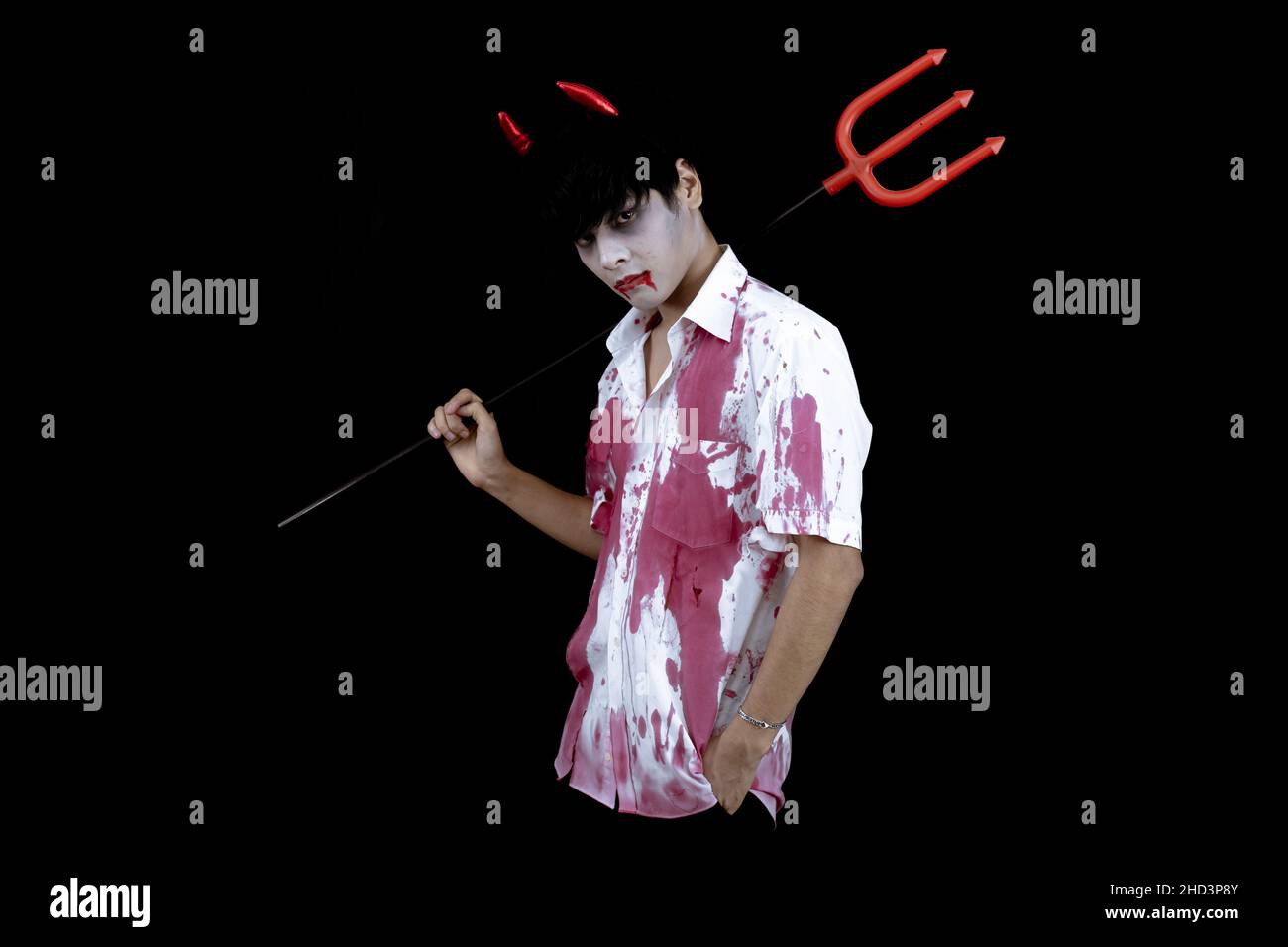 Costume de jeune homme asiatique en enfer, mal sur fond noir avec concept pour Halloween festival de mode en studio.Adolescent asiatique dans le cosplay Halloween. Banque D'Images