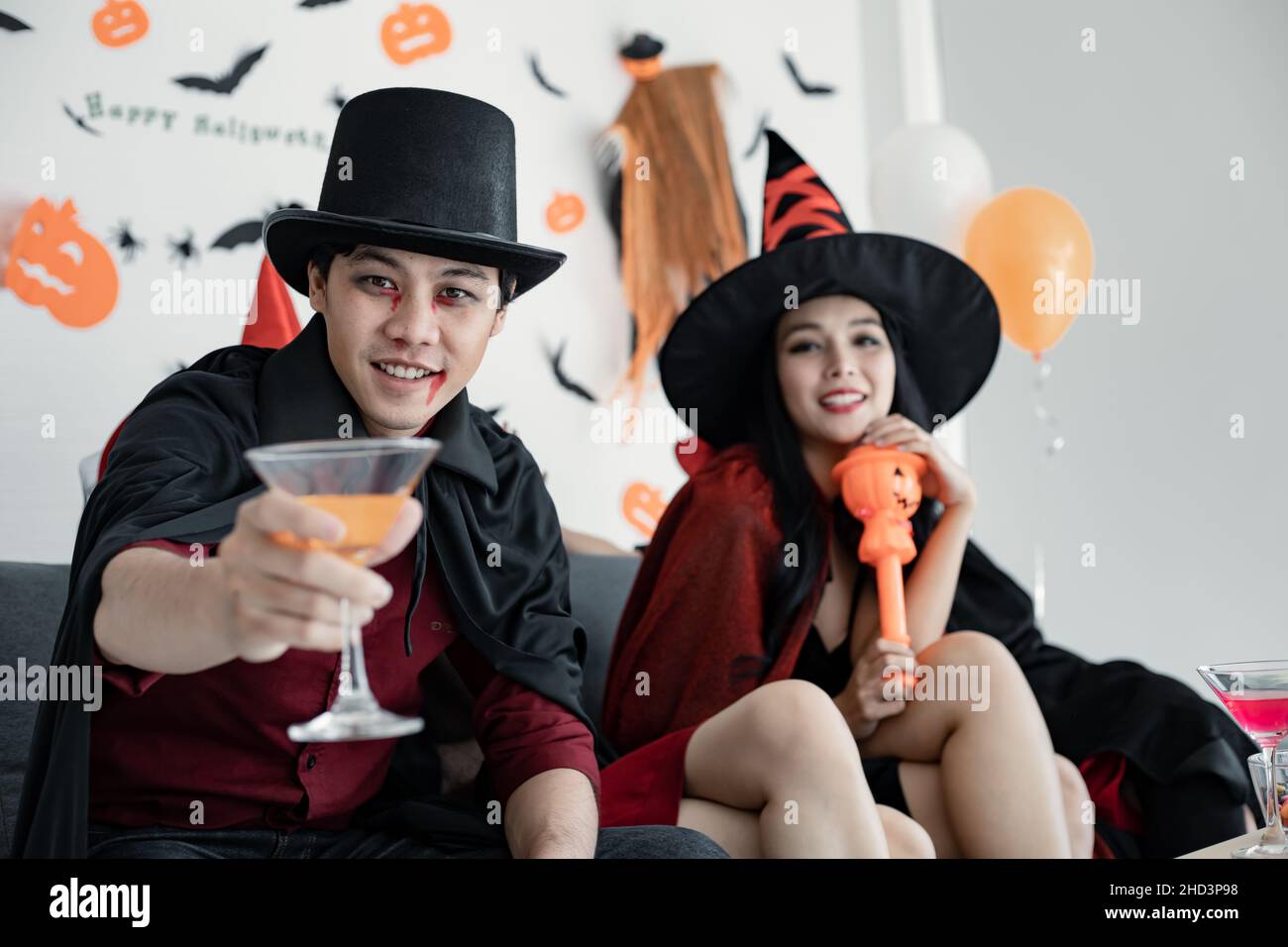 Regroupez les jeunes asiatiques en sorcière déguisée, assistant fêtez la fête avec un verre dans la salle pour le thème Halloween.Gang Teen Thai avec fête d'Halloween fête W Banque D'Images