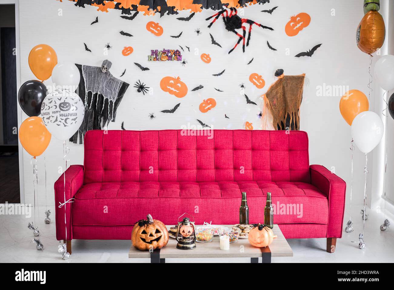 Canapé rouge dans la chambre avec scène est mis Halloween.Décoration suspendue, scènes dans le festival d'Halloween sur le mur dans la salle.Décoration de la décoration à Hallo Banque D'Images