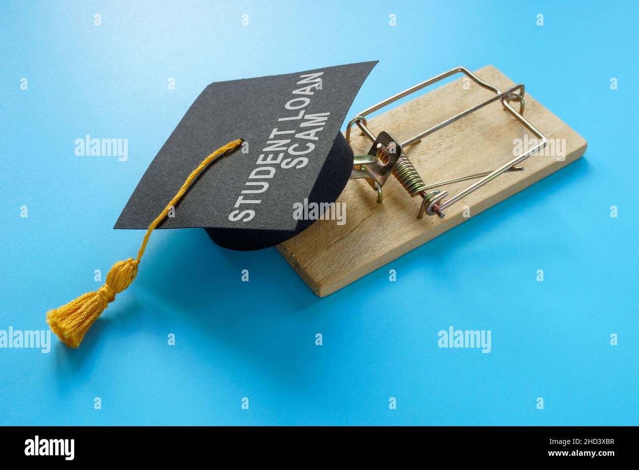 Concept d'escroquerie de prêt étudiant.Piège à souris et chapeau de graduation. Banque D'Images