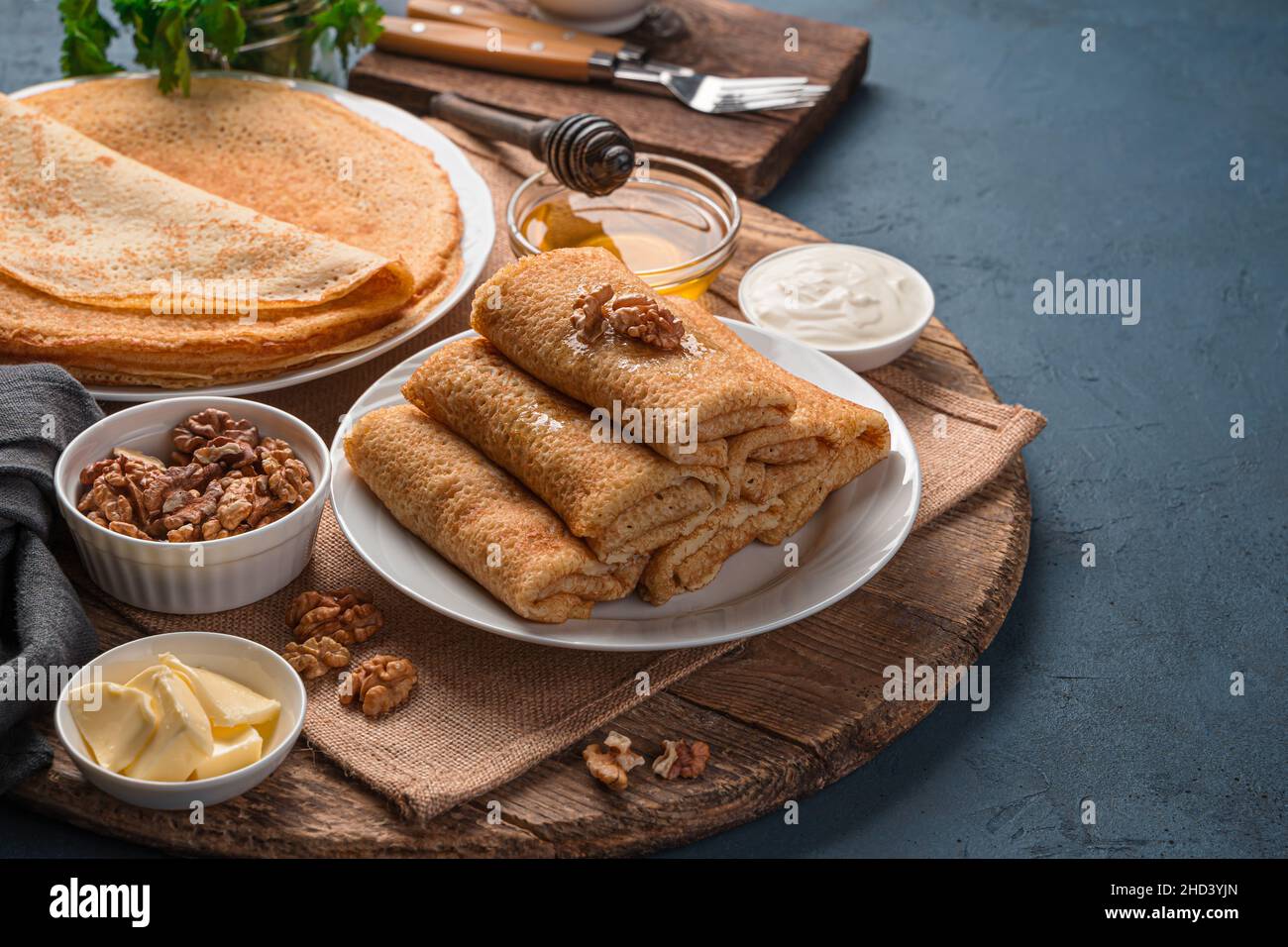 Crêpes fourrées maison avec fromage cottage sur fond de noix, de miel et de crème aigre. Banque D'Images