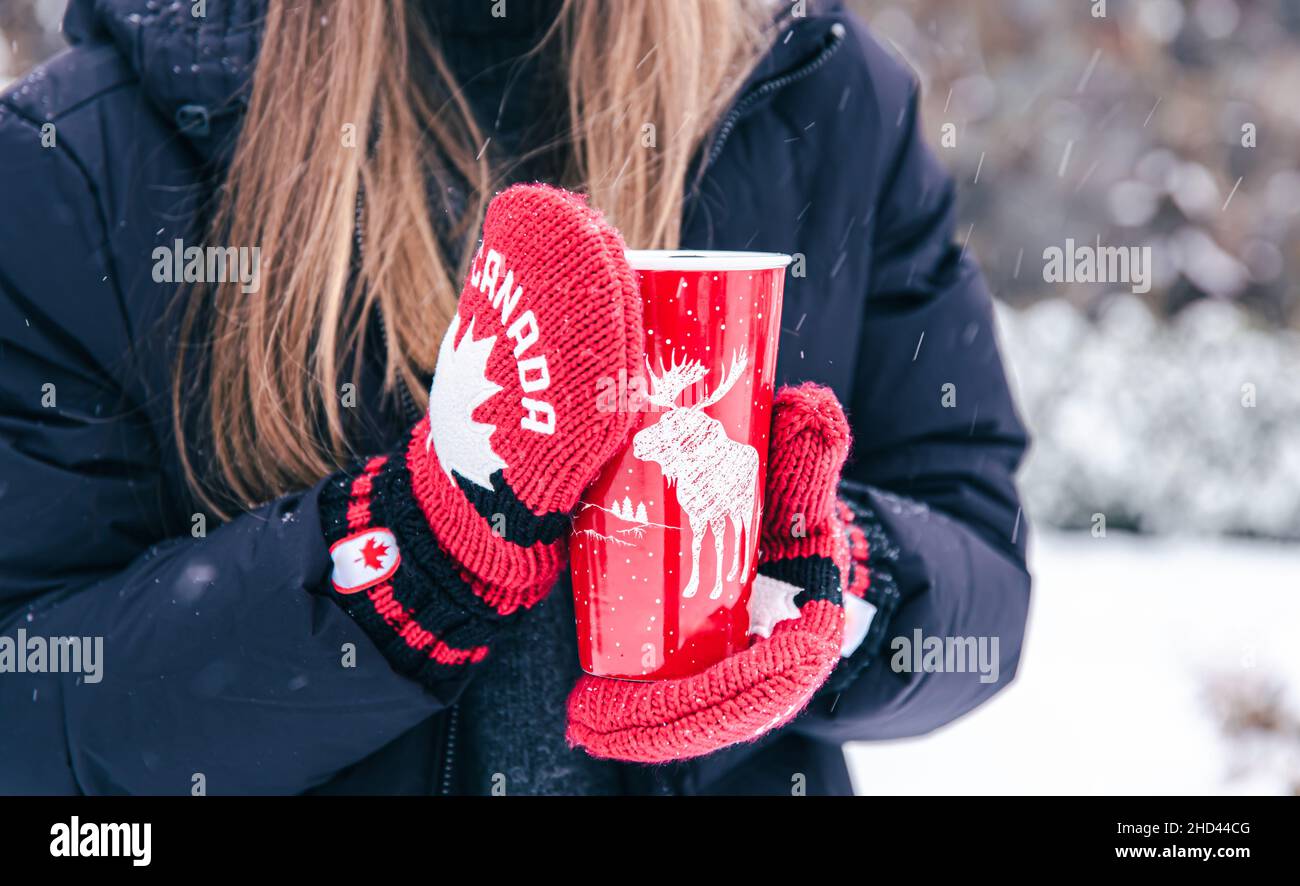 Gros plan des mains des femmes au Canada les moufles tiennent une coupe  chaude rouge Photo Stock - Alamy