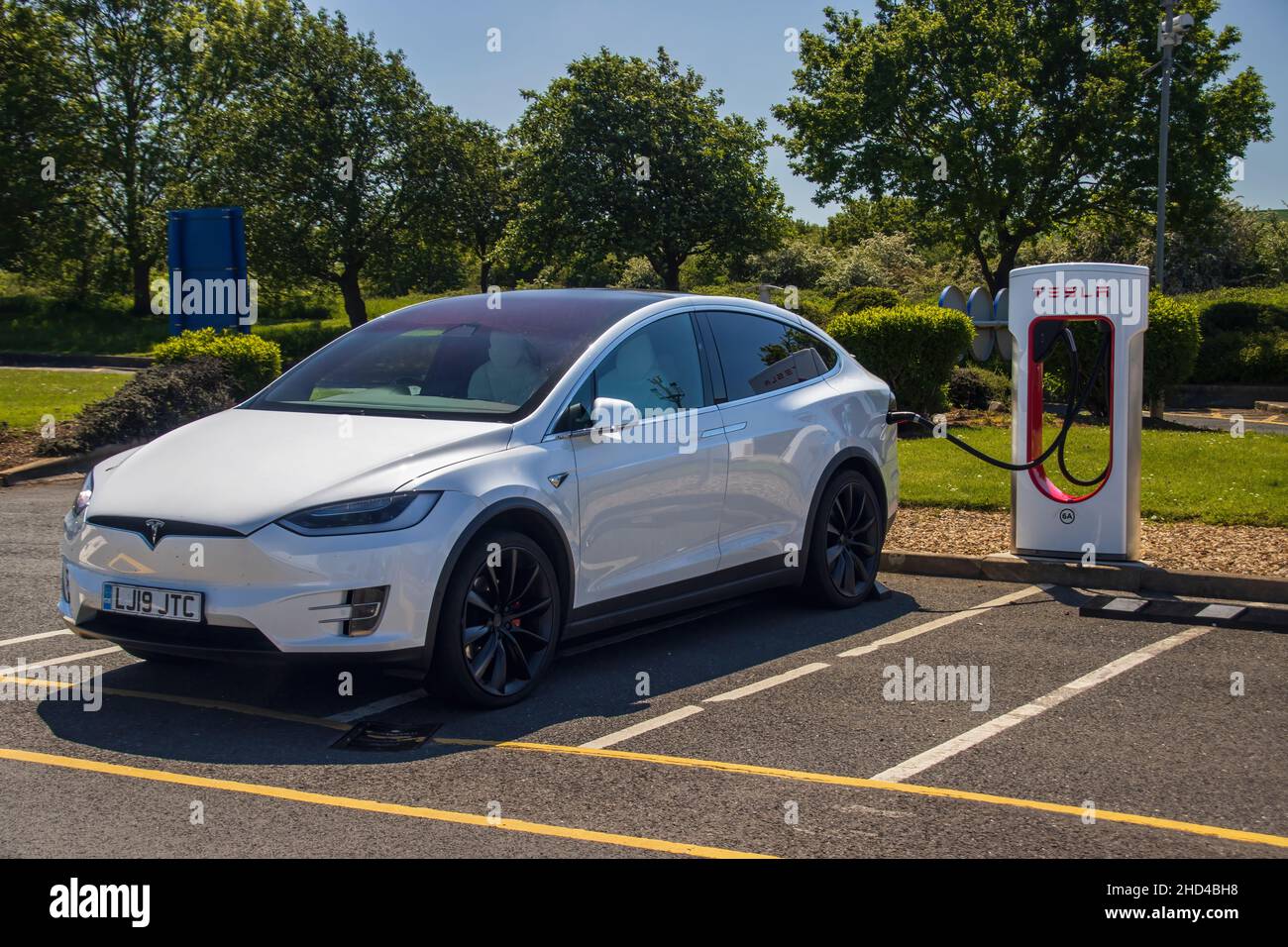 Grantham, Royaume-Uni - Mai 30th 2021: Un whiteTesla modèle x branché dans un compresseur à un service d'autoroute.Photo de haute qualité Banque D'Images