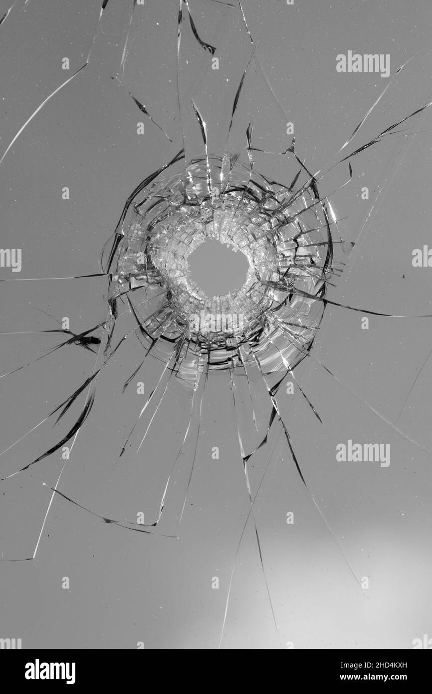 Collage de fissures dans le verre, un trou de balles dans le verre sur un fond blanc. Texture de verre de fenêtre. Banque D'Images