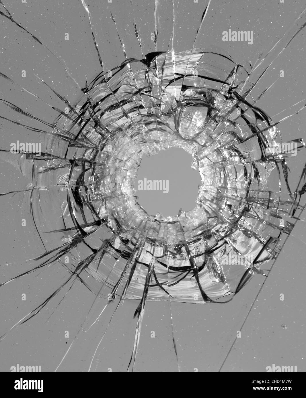 Collage de fissures dans le verre, un trou de balles dans le verre sur un fond blanc. Texture de verre de fenêtre. Banque D'Images