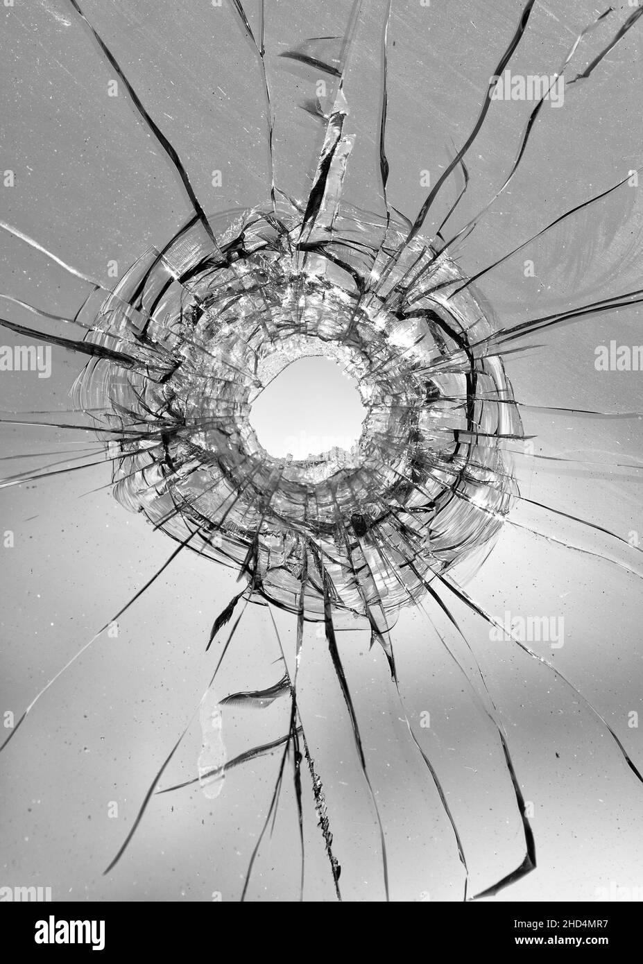 Collage de fissures dans le verre, un trou de balles dans le verre sur un fond blanc. Texture de verre de fenêtre. Banque D'Images
