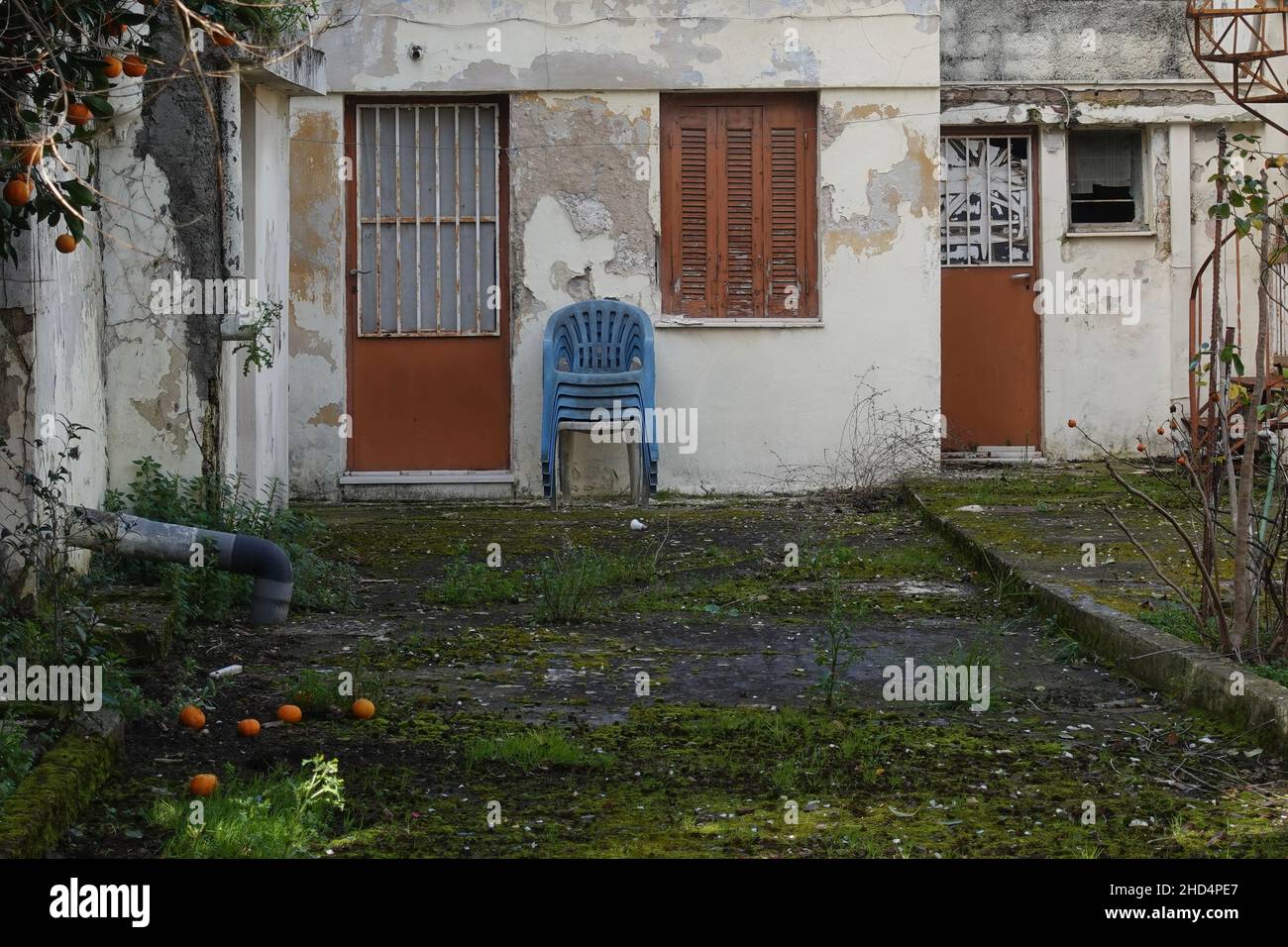 Extérieur de la maison abandonnée avec fruits pourris sur cour gazée. Banque D'Images