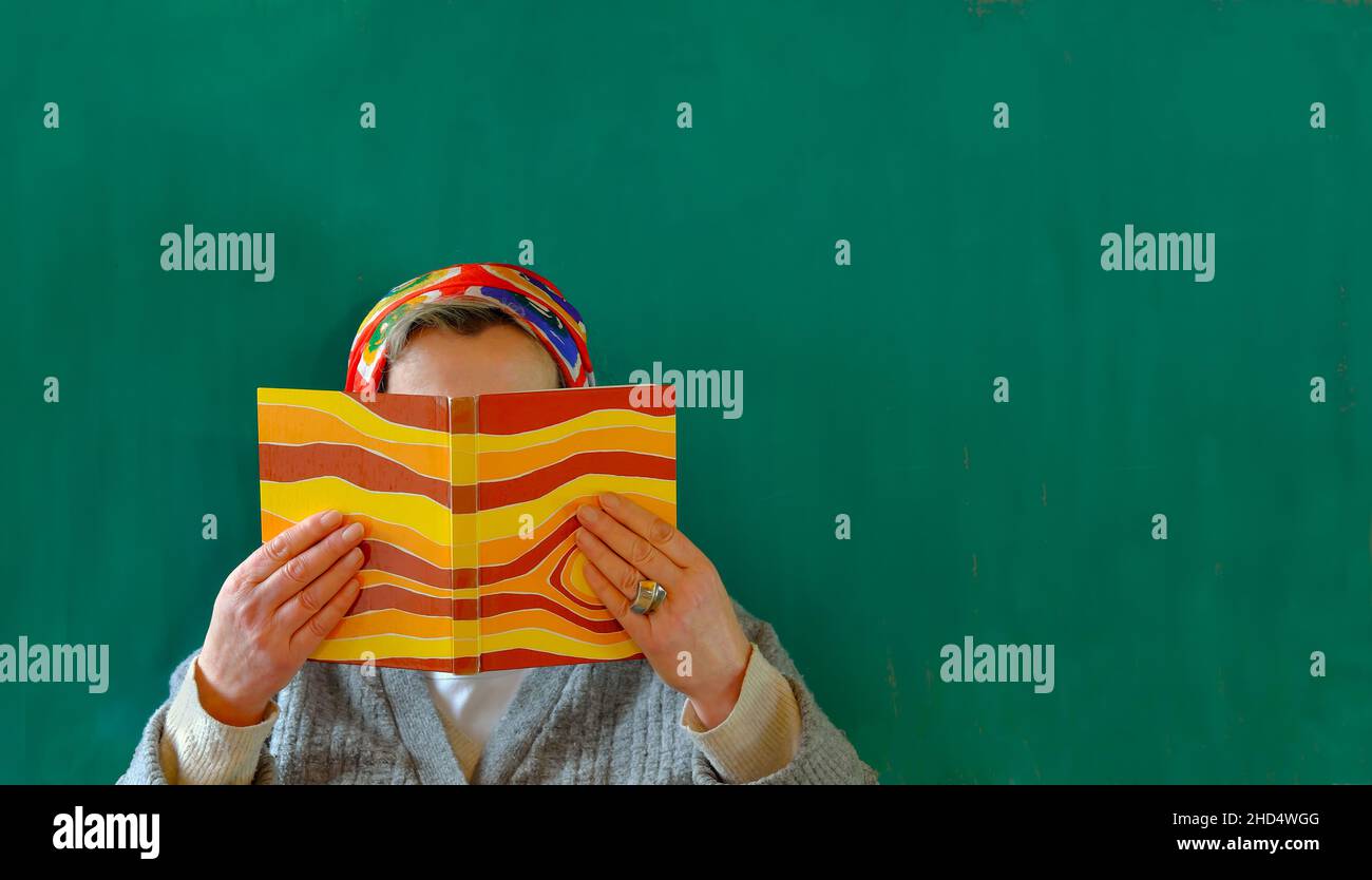 femme âgée avec bandanna lisant un livre, éducation, lecture, roman, personne méconnaissable, espace de copie gratuit Banque D'Images