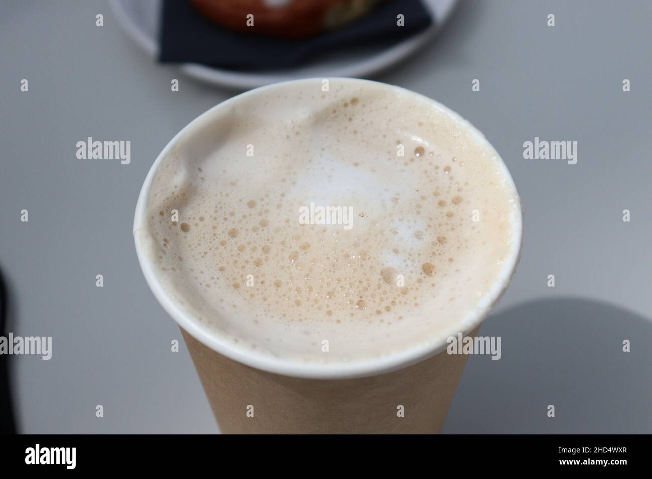 Un latte mousseux dans une tasse à emporter Banque D'Images
