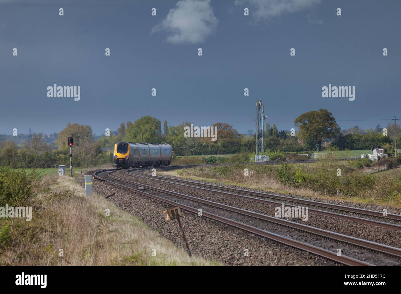 CrossCountry train avec un signal de danger derrière lui, le signal se met automatiquement en danger lorsque le train passe, Stoke Orchard, Gloucestershire, Royaume-Uni Banque D'Images