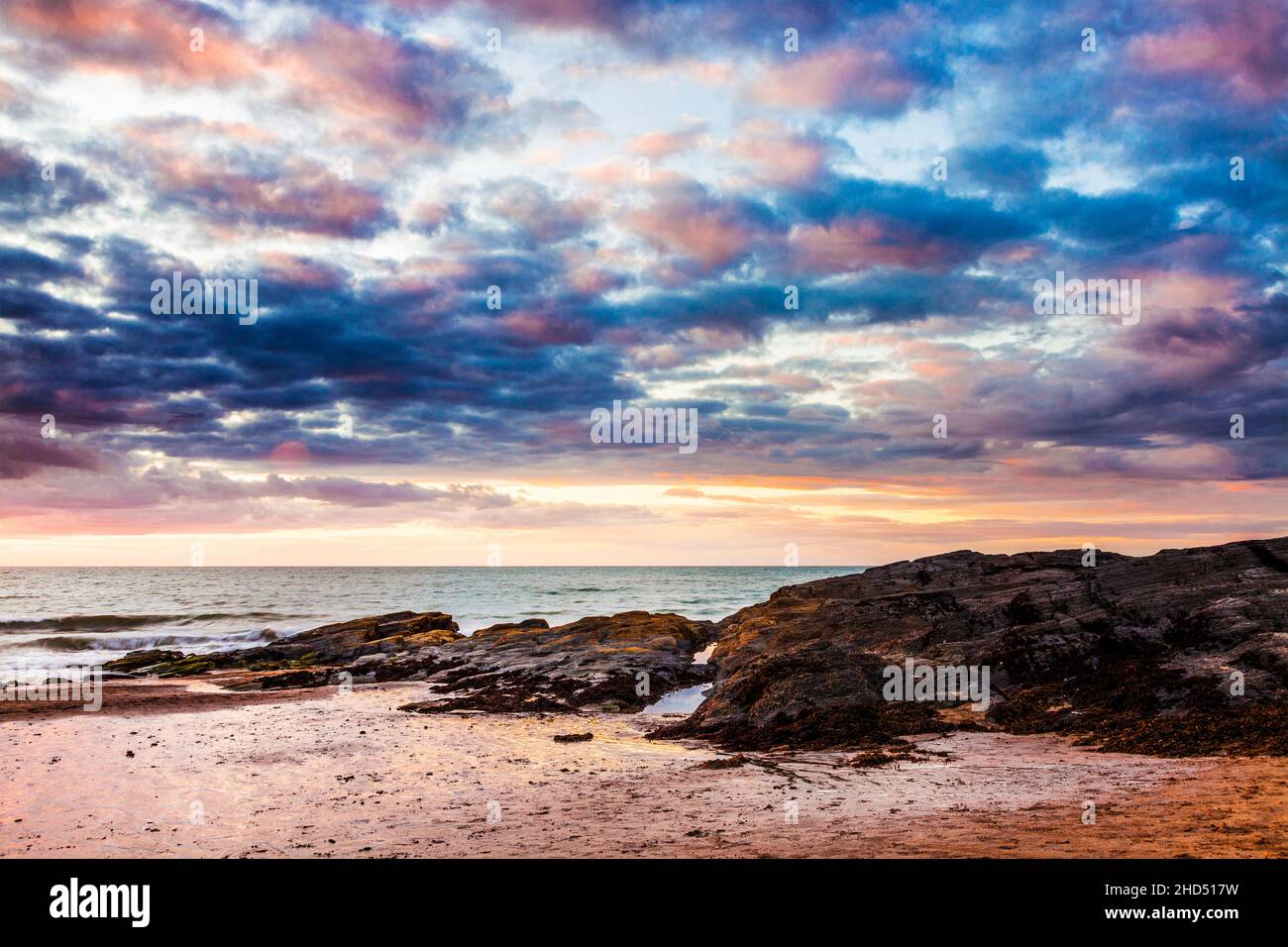 Coucher de soleil sur la plage de Tresaith à Ceredigion au pays de Galles. Banque D'Images