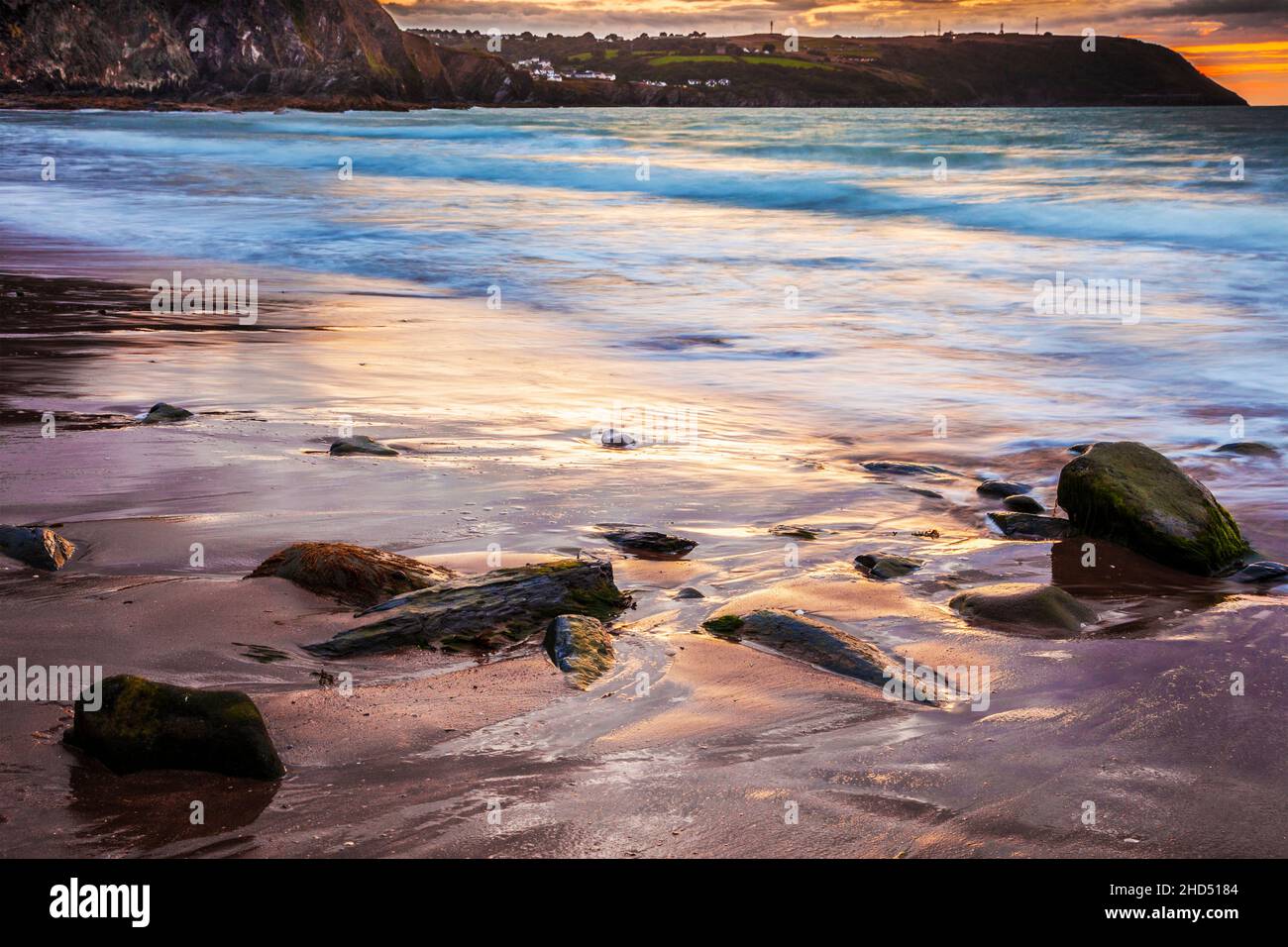 Coucher de soleil sur la plage de Tresaith à Ceredigion en direction d'Aberporth. Banque D'Images