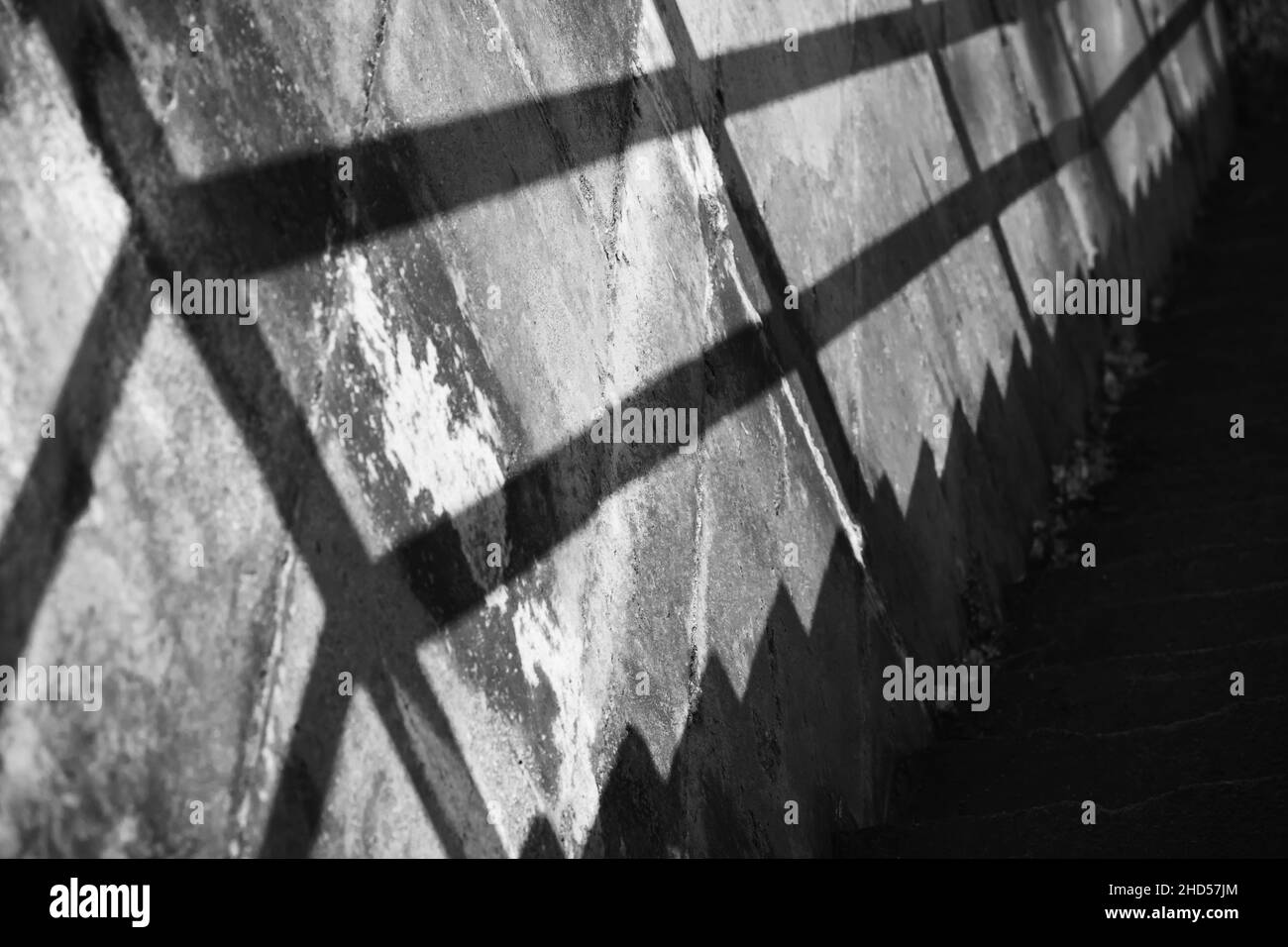 Photo abstraite en noir et blanc avec une perspective et une ombre d'escalier en béton grundy sur le mur Banque D'Images