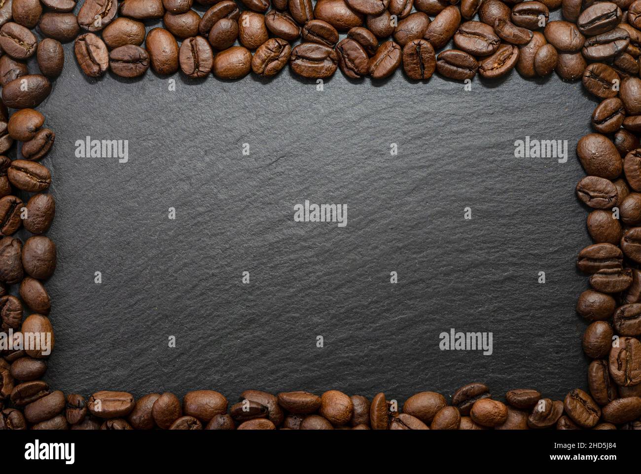 Composition du cadre de grains de café sur fond de carreaux de pierre noire Banque D'Images
