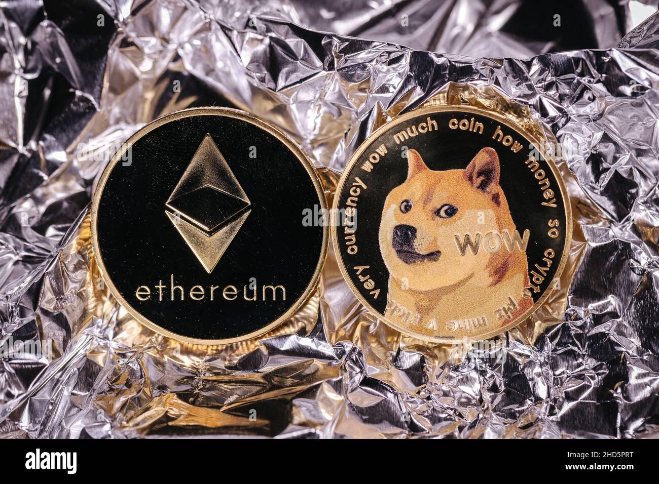 Ethereum et dogecoin crypto-monnaie, pièces physiques devant un fond abstrait. Banque D'Images