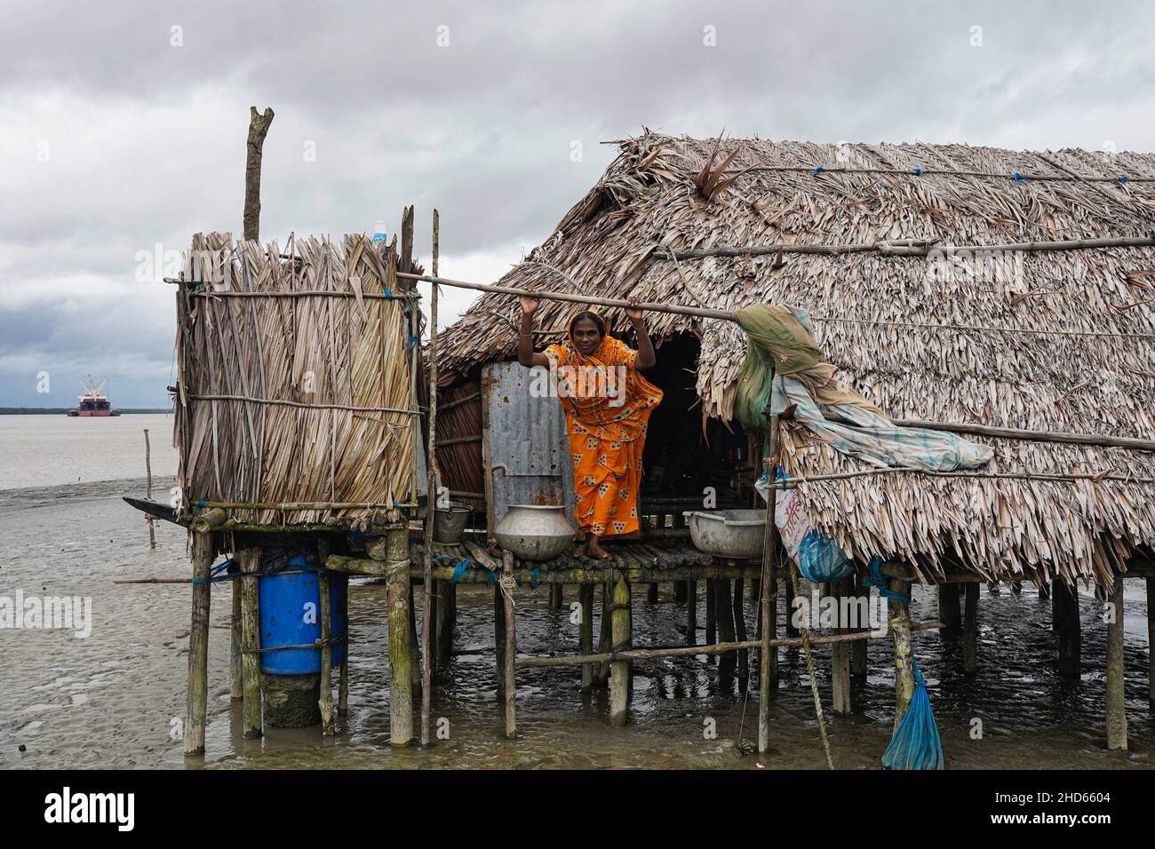 Mongla, Bangladesh.12th septembre 2021.Une femme se tient devant sa maison qui est rétablie plusieurs fois en raison d'un cyclone dans la zone côtière du village de Jaymani. Le Bangladesh est l'un des pays les plus vulnérables aux effets du changement climatique.Les dangers naturels réguliers et graves que le Bangladesh souffre déjà de cyclones tropicaux, de marées hautes, d'érosion des rivières, d'inondations, de glissements de terrain et de sécheresse sont tous sur le point d'augmenter en intensité et en fréquence en raison du changement climatique.(Image de crédit : © Sultan Mahmud Mukut/SOPA Images via ZUMA Press Wire) Banque D'Images