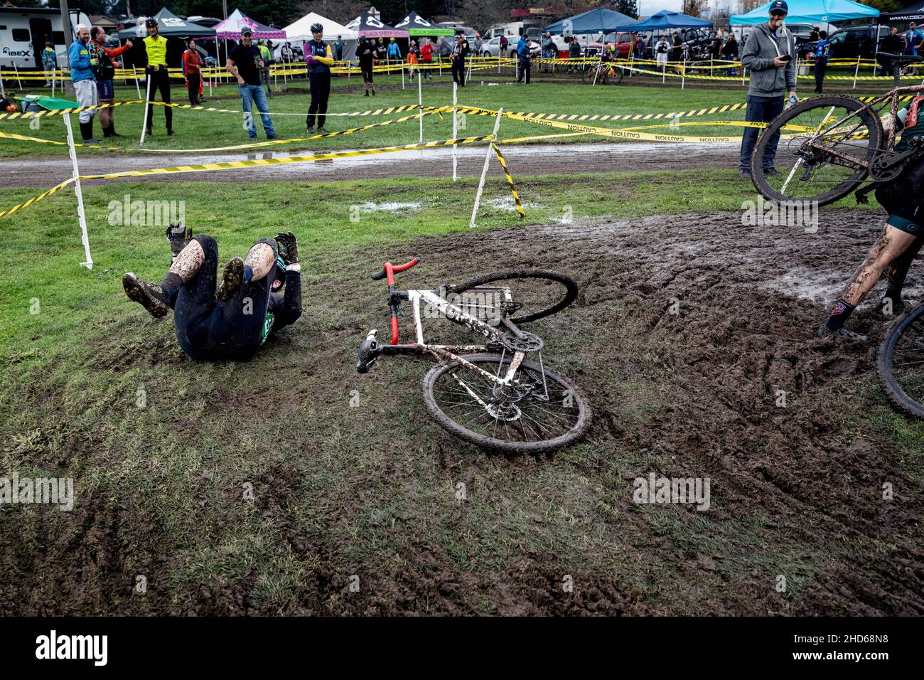 WA20605-00......WASHINGTON - un cycliste se renverse sur un coin boueux lors d'une course de cyclocross féminin. Banque D'Images