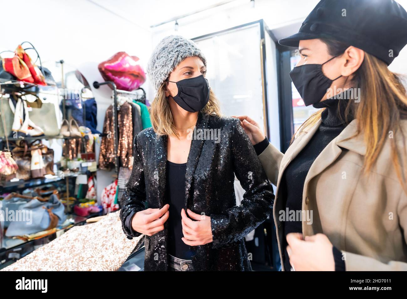 Employé et client avec des masques dans un magasin de vêtements de luxe, mesures de sécurité dans la pandémie du coronavirus, Covid-19 Banque D'Images