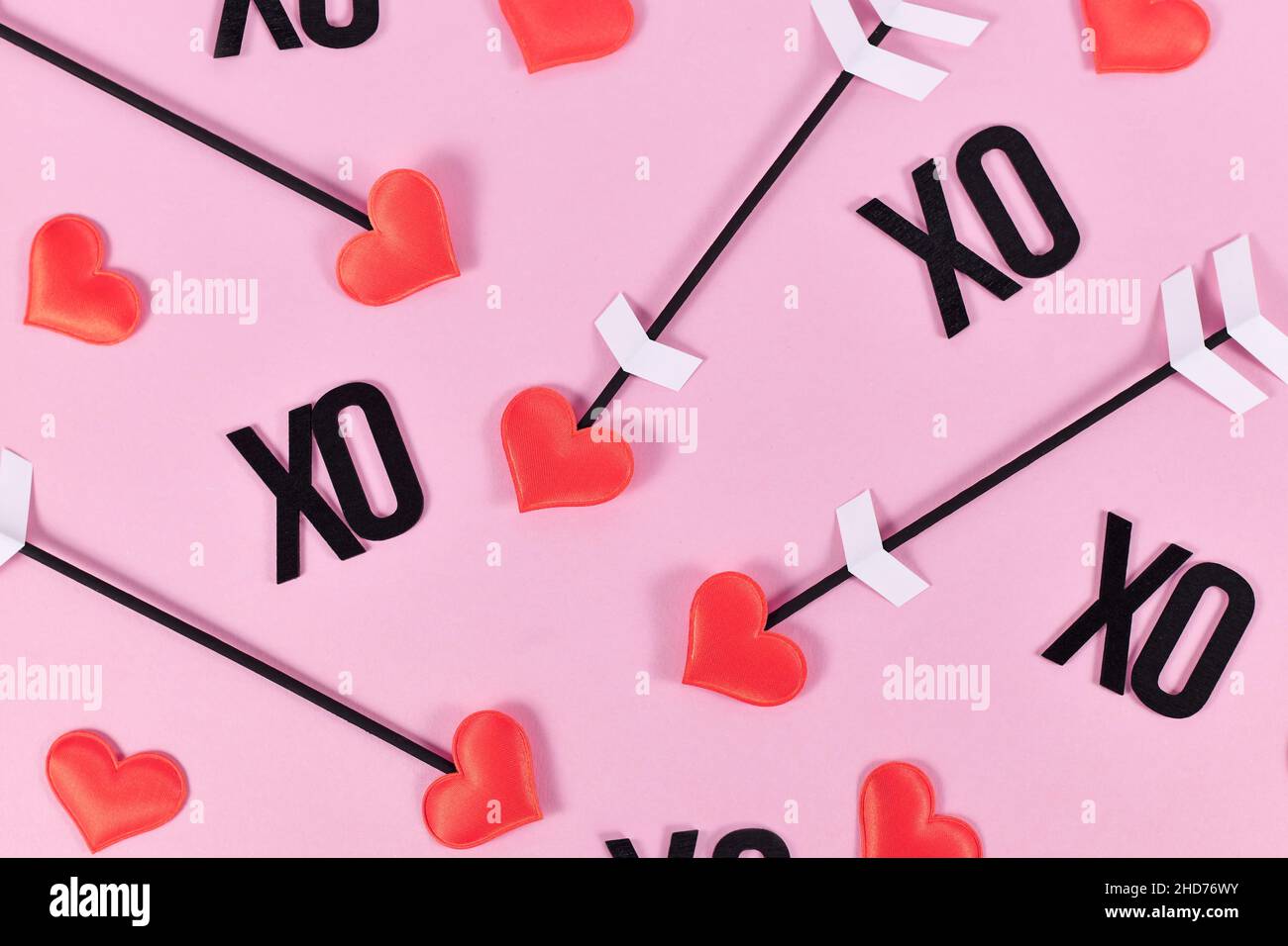 Saint-Valentin plat avec flèches d'amour de cupid et texte XO sur fond rose Banque D'Images
