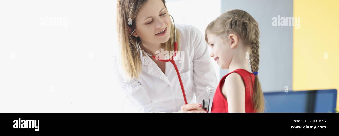 Le médecin pédiatre écoute la respiration et le battement de coeur avec le stéthoscope de la petite fille. Banque D'Images