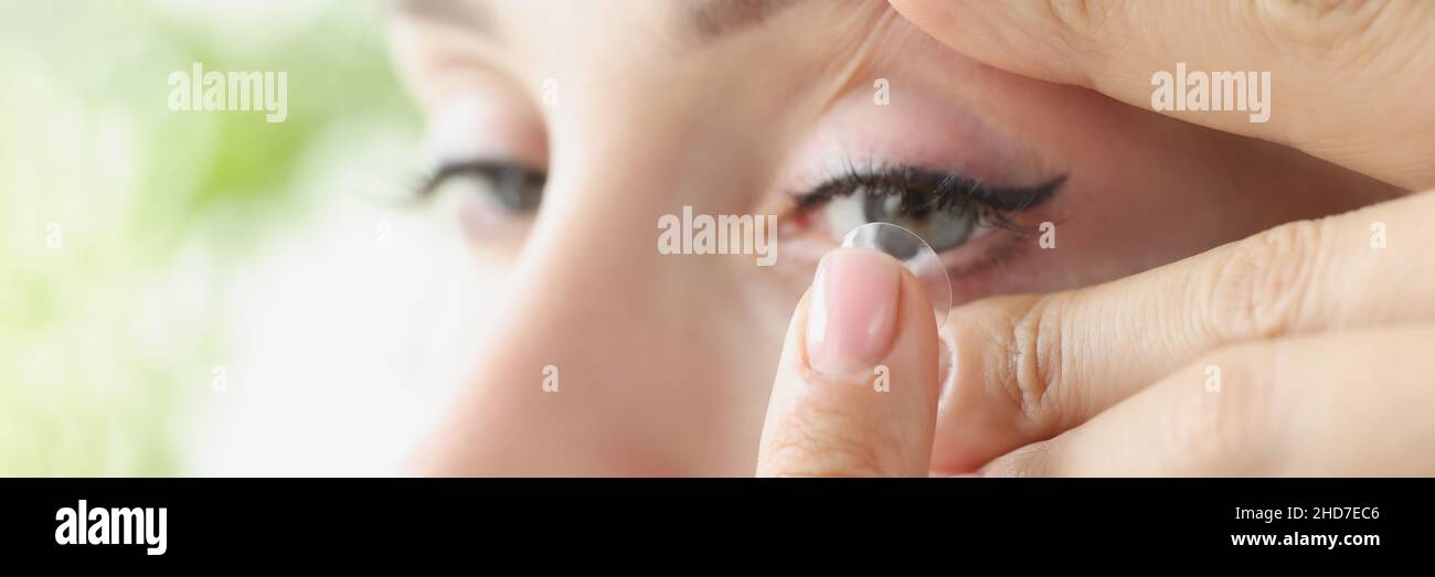 Une jeune femme met des lentilles de contact souples sur un gros plan des yeux Banque D'Images