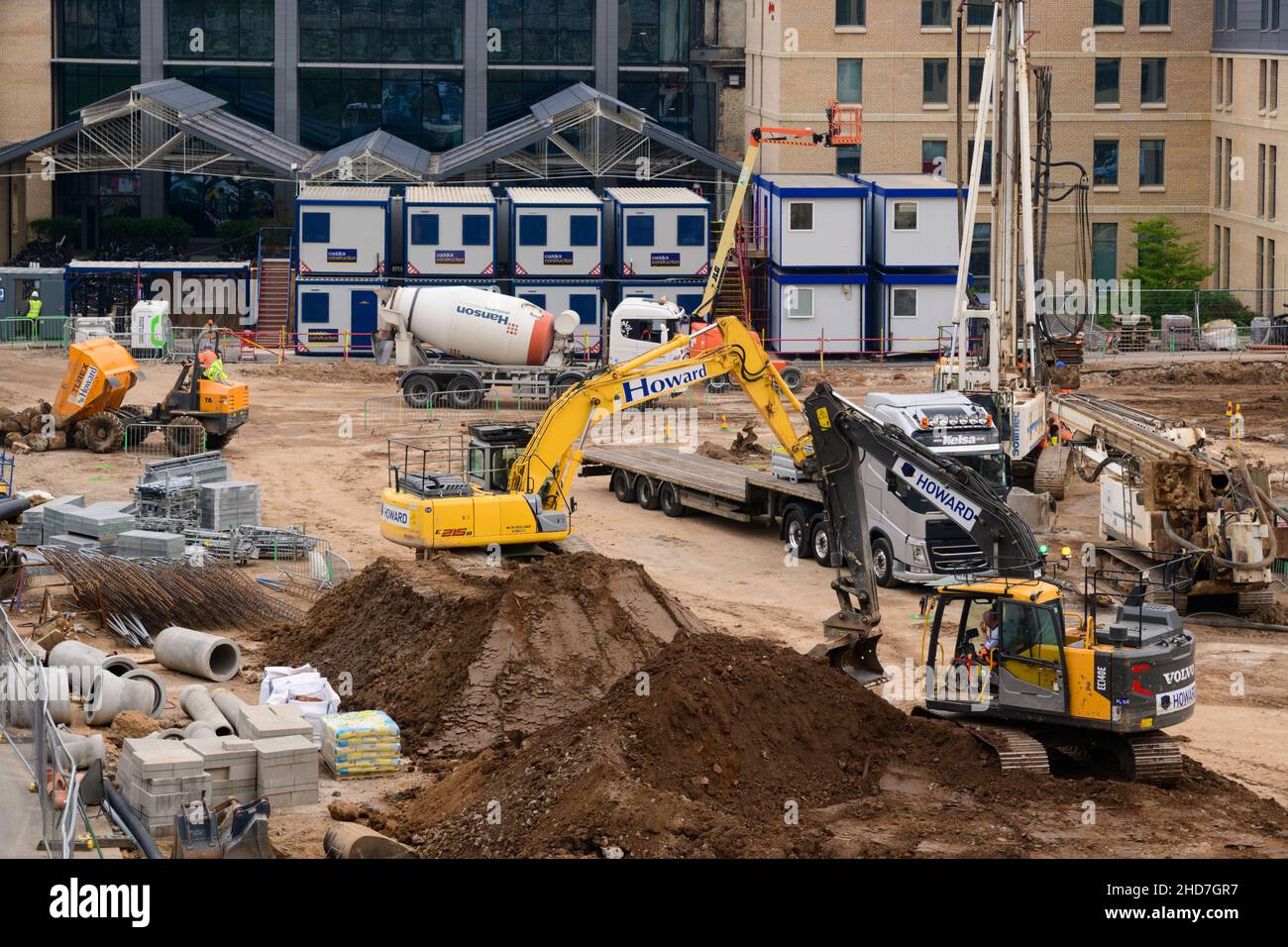Chantier de construction occupé (matériaux de construction, variété de véhicules, pelles hydrauliques, mélangeur de ciment) - Hudson Quarter, North Yorkshire Angleterre Royaume-Uni. Banque D'Images