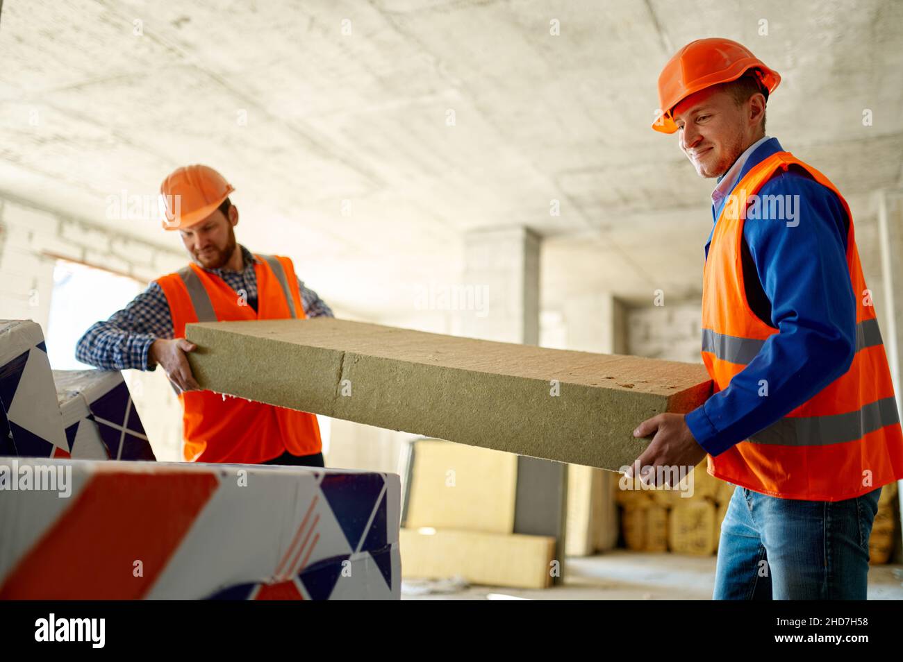 Deux constructeurs déchargent les matériaux de construction à l'entrepôt Banque D'Images