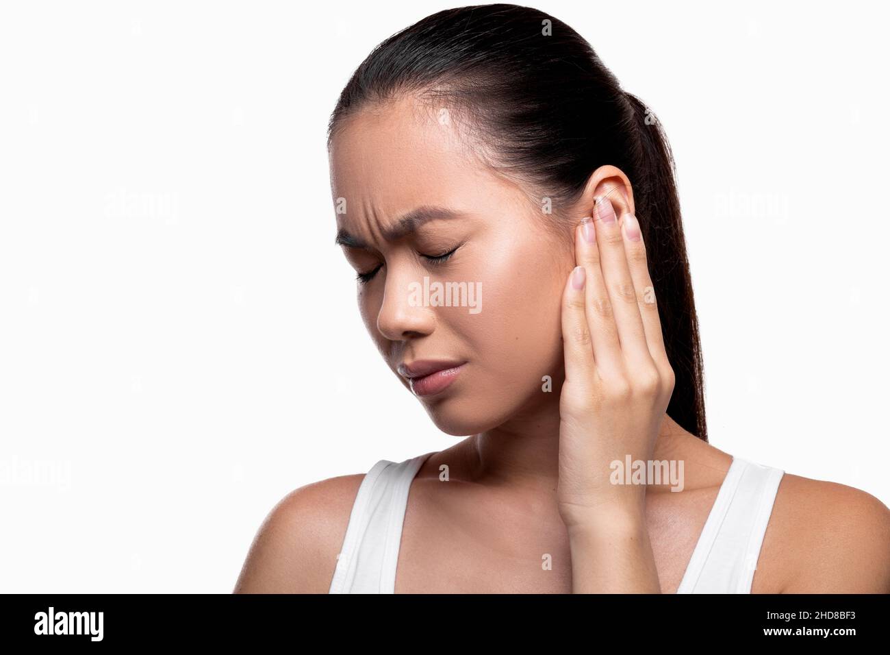 Femme asiatique ayant des douleurs d'oreille, fond blanc de studio Banque D'Images