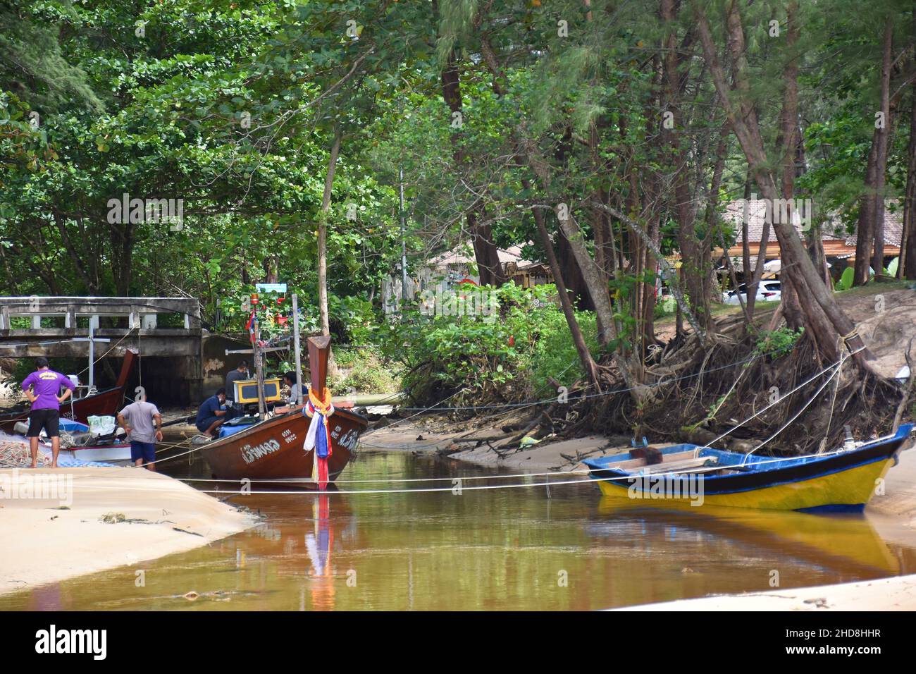 Bateaux de pêcheurs colorés situés dans un système estuarien à la plage de Sirinat N.P. sur l'île de Phuket, en Thaïlande Banque D'Images