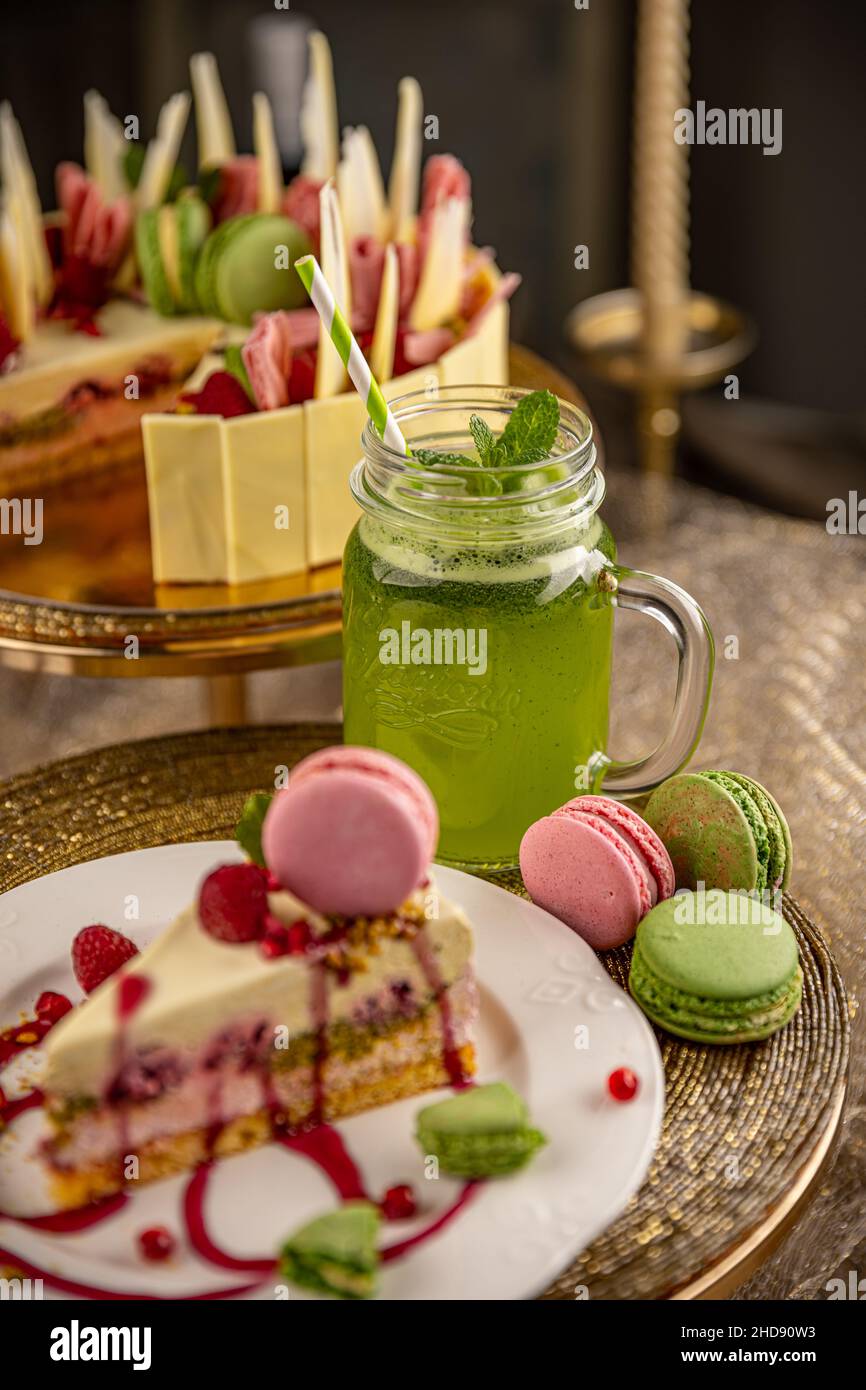 Délicieux gâteau d'anniversaire décoré de macarons et servi avec de la limonade à la menthe Banque D'Images