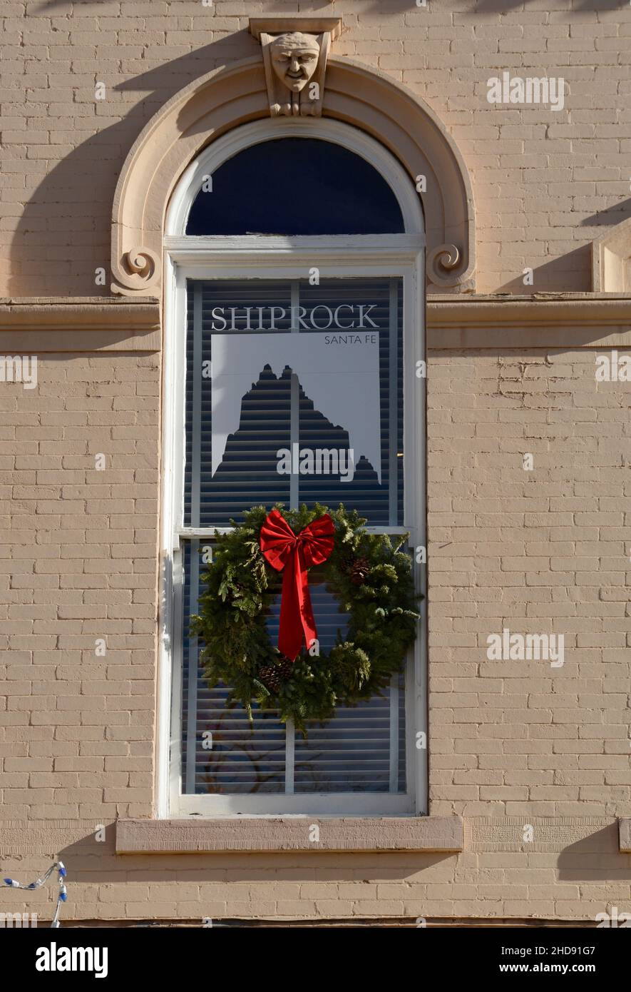 Une couronne de Noël est suspendue dans la fenêtre d'une galerie d'art et d'antiquités amérindiennes du Sud-Ouest à Santa Fe, Nouveau-Mexique. Banque D'Images