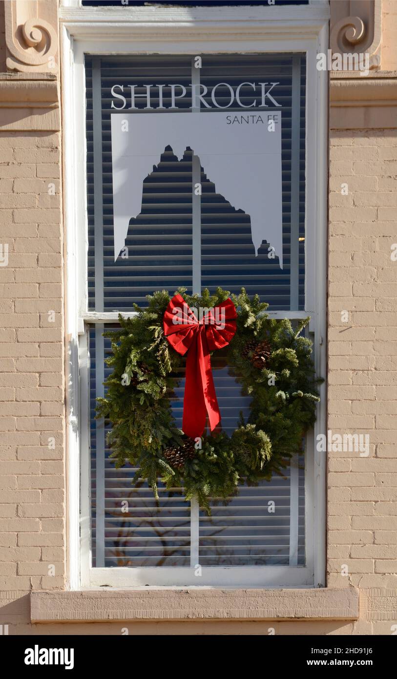 Une couronne de Noël est suspendue dans la fenêtre d'une galerie d'art et d'antiquités amérindiennes du Sud-Ouest à Santa Fe, Nouveau-Mexique. Banque D'Images