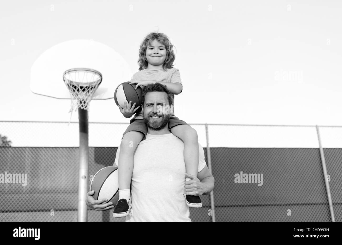 un père et un fils heureux jouent au basket-ball avec un ballon sur le terrain de jeu, l'ensemble Banque D'Images