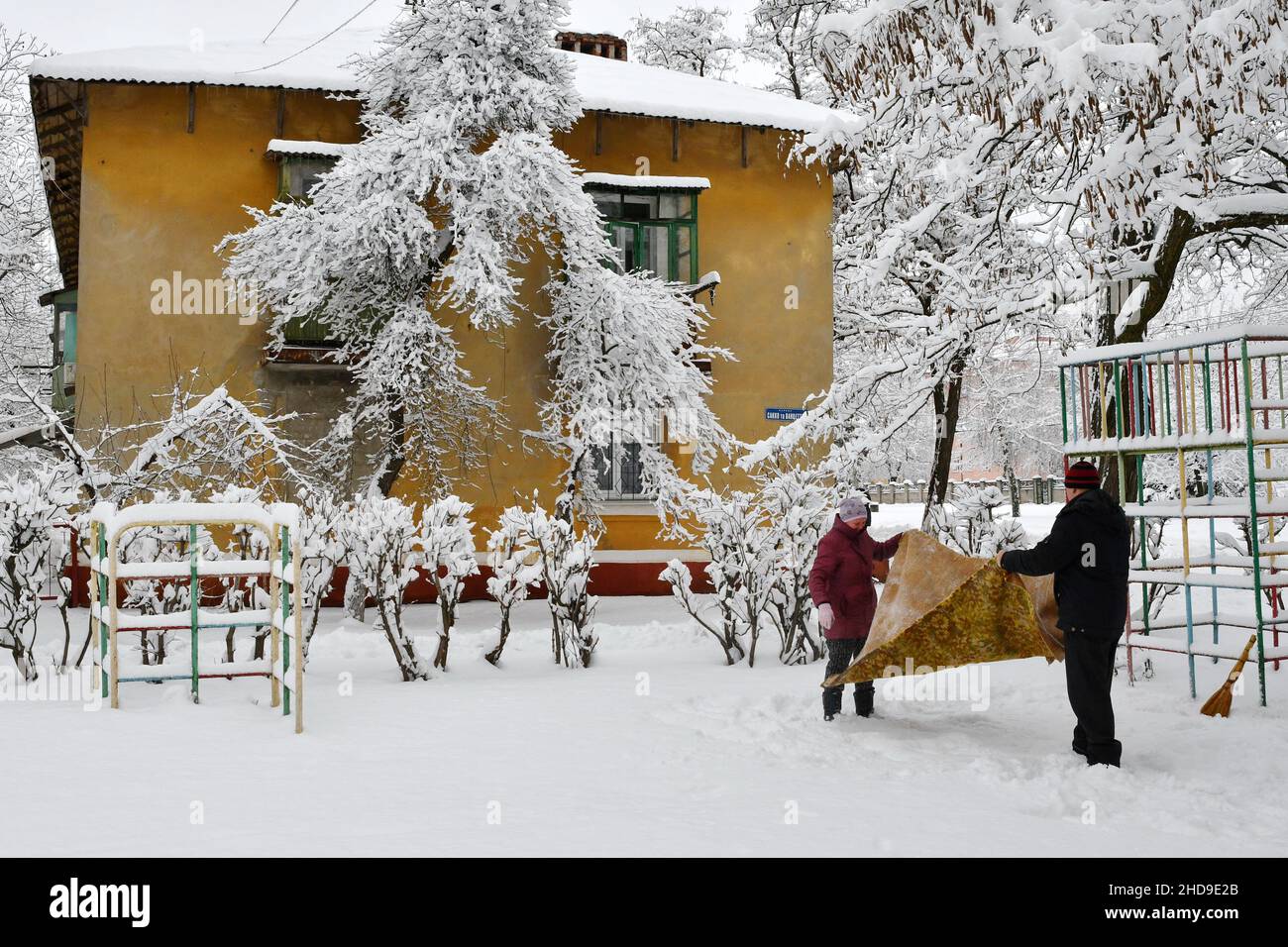 Kramatorsk, Ukraine.26th décembre 2021.On voit des personnes âgées nettoyer la moquette avec de la neige.Le nettoyage de la neige des tapis en plein air est une vieille tradition chez les Ukrainiens.(Photo par Andriy Andriyenko/SOPA Images/Sipa USA) crédit: SIPA USA/Alay Live News Banque D'Images