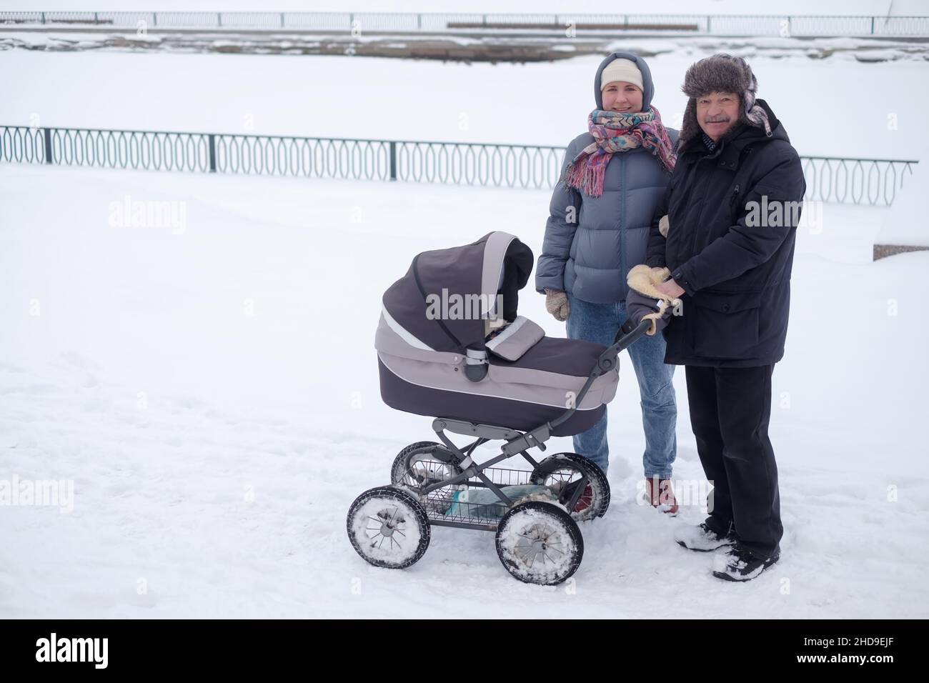 Mère et grand-père marchant avec l'enfant dans la poussette Banque D'Images