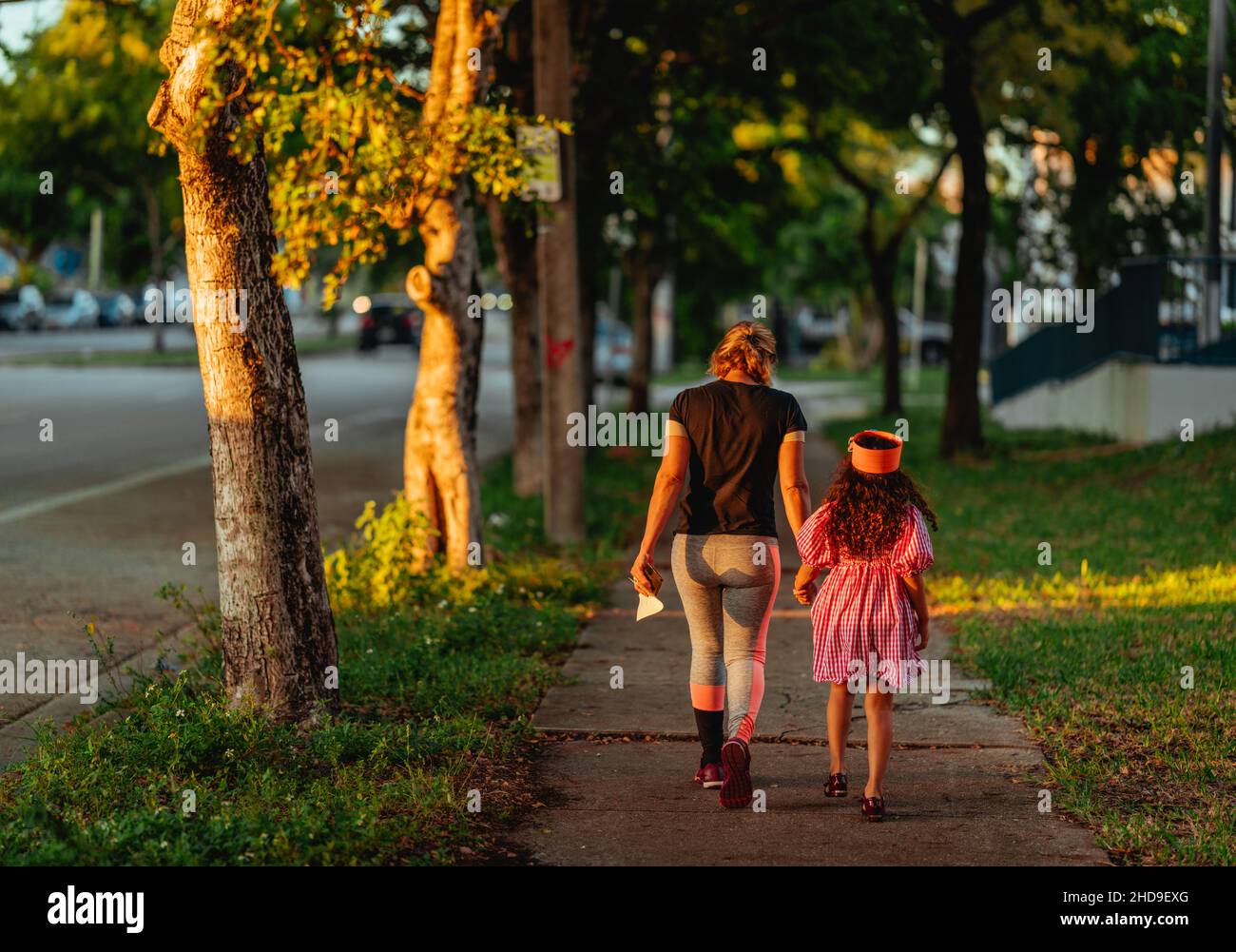 Mère et fille marchant ion le parc lors d'une soirée ensoleillée avec un arrière-plan flou Banque D'Images