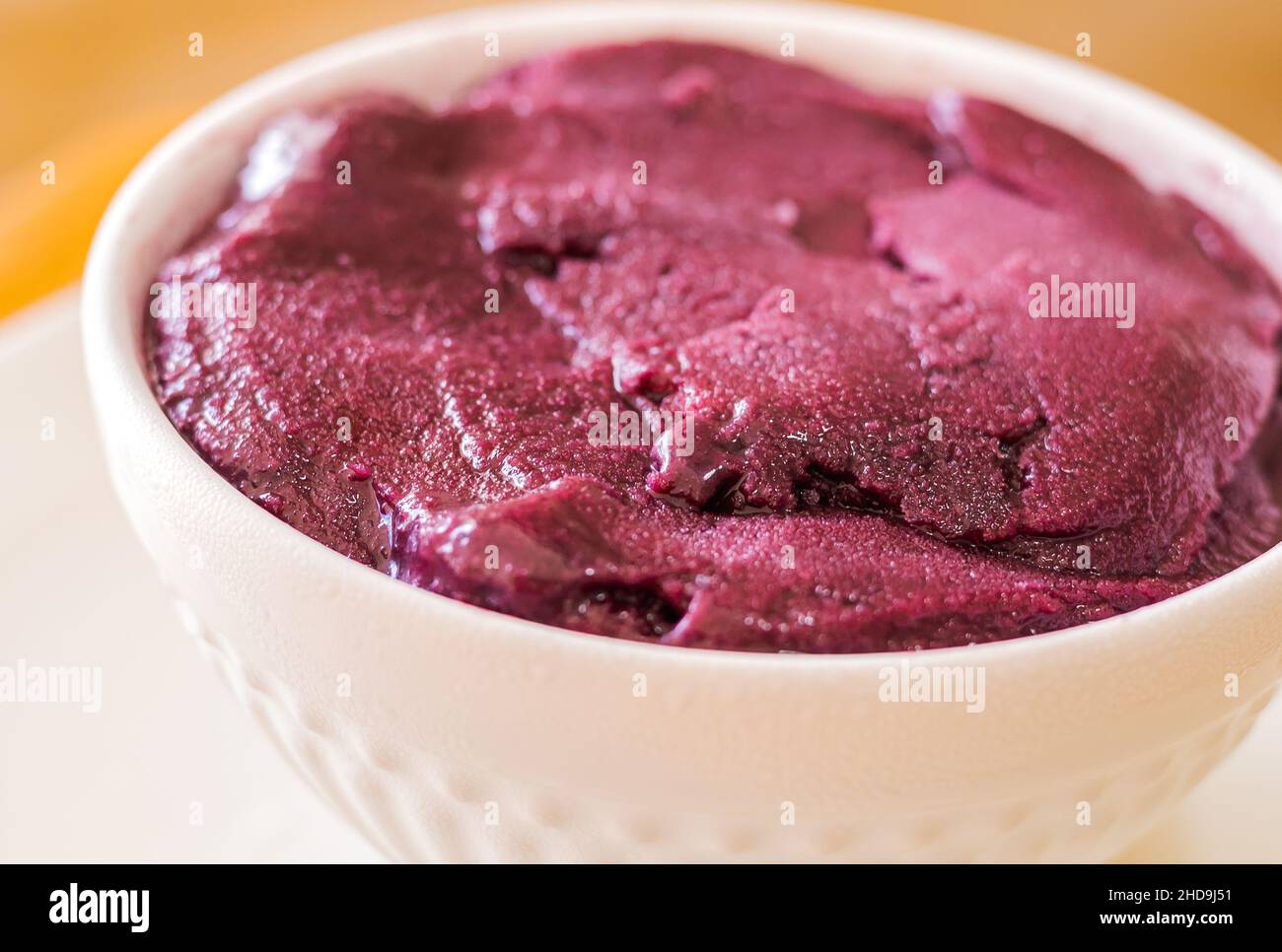 açaí congelé servi dans un bol blanc en gros plan photo sur fond de bois.Cuisine brésilienne. Banque D'Images