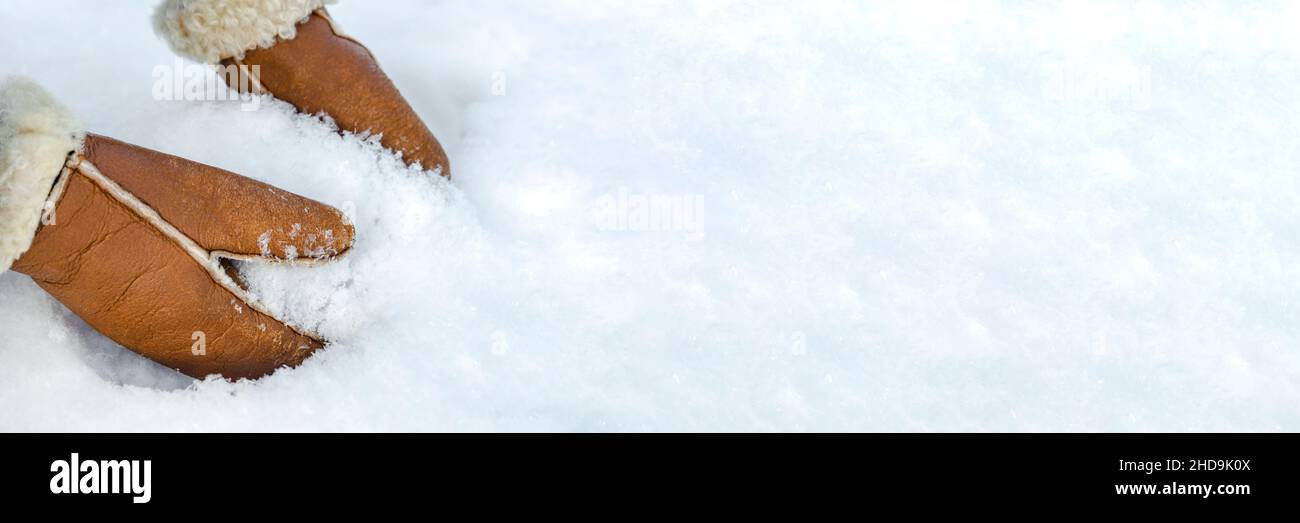 Femme en cuir moufles roule une boule de neige à l'extérieur, gros plan.Les  mains des moufles chaudes font de la neige en hiver.Moufles en cuir marron  dans la neige en hiver Photo