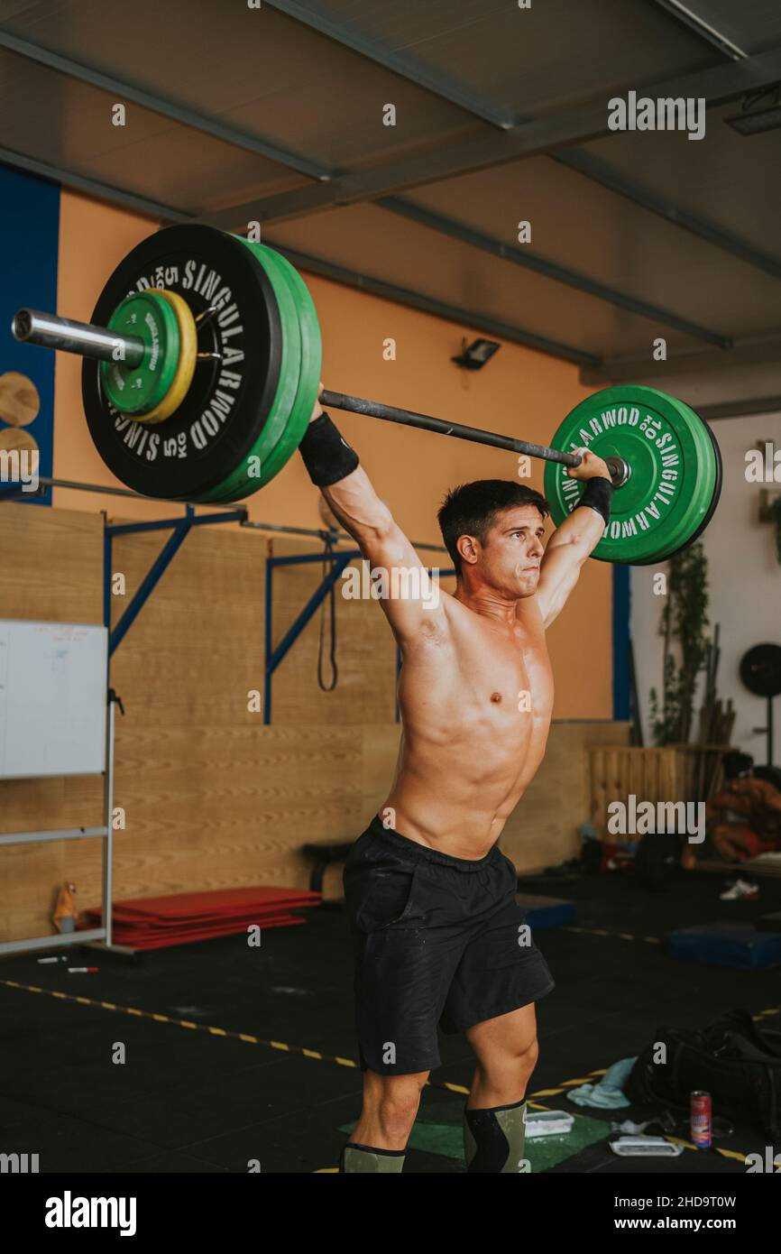 Jeune athlète masculin espagnol musclé s'entraîner dans une salle de gym levée de barbell. Le concept de CrossFit sport Banque D'Images