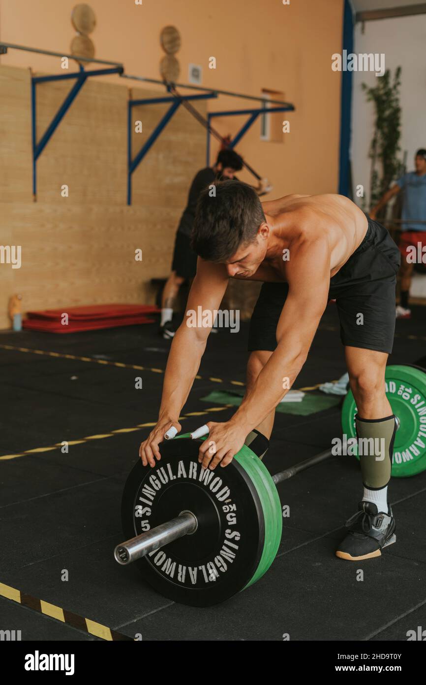 Jeune athlète masculin espagnol musclé s'entraîner dans une salle de gym levée de barbell. Le concept de CrossFit sport Banque D'Images