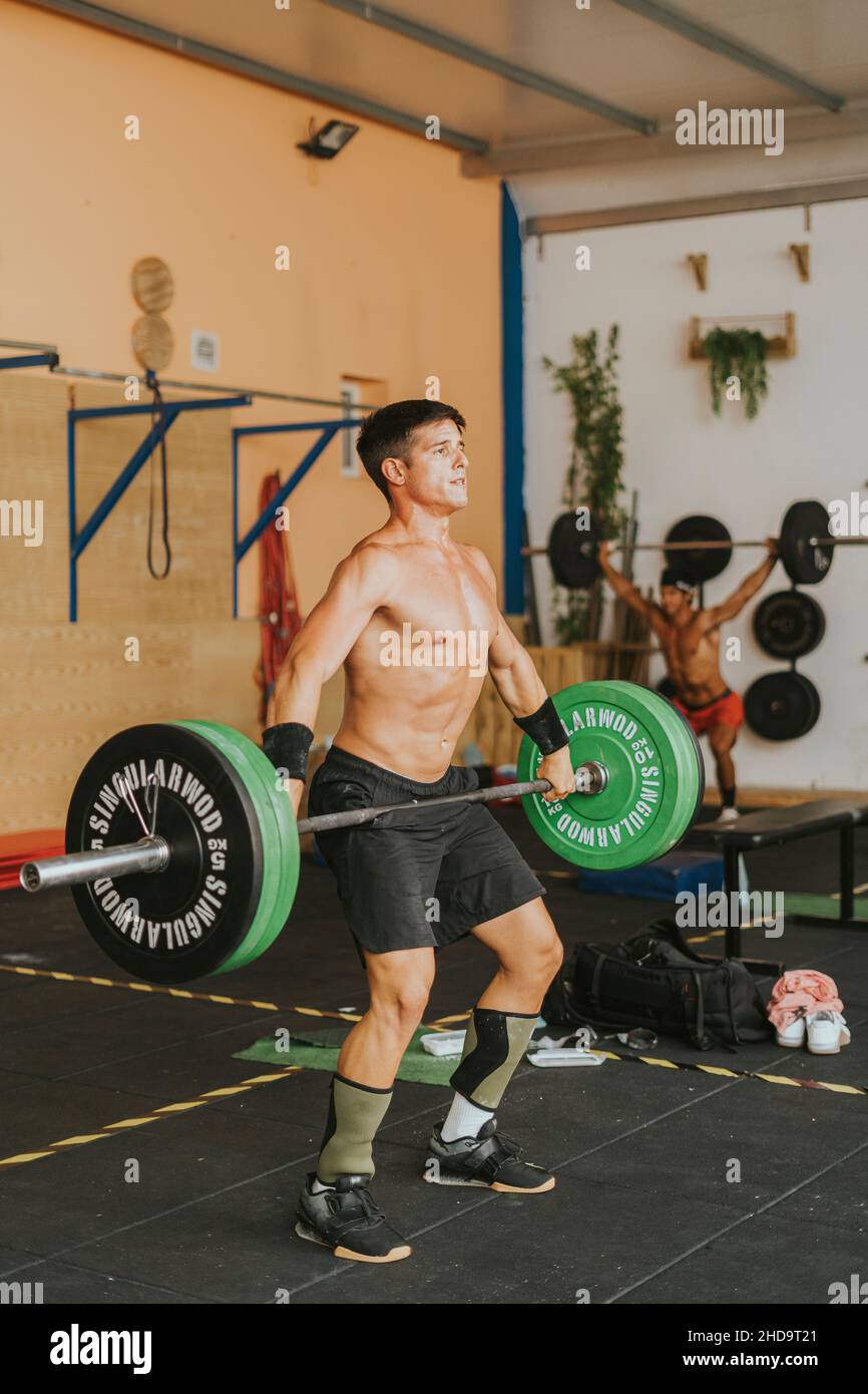 Jeune athlète masculin espagnol musclé s'entraîner dans une salle de gym levée de barbell. Le concept de CrossFit sport Banque D'Images