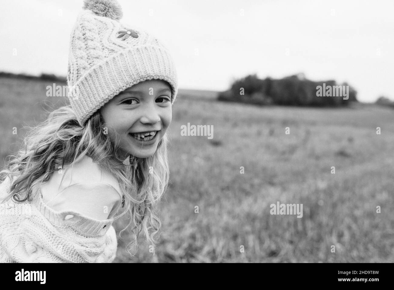 portrait d'une fille en train de rire et de jouer dans un champ à l'automne Banque D'Images
