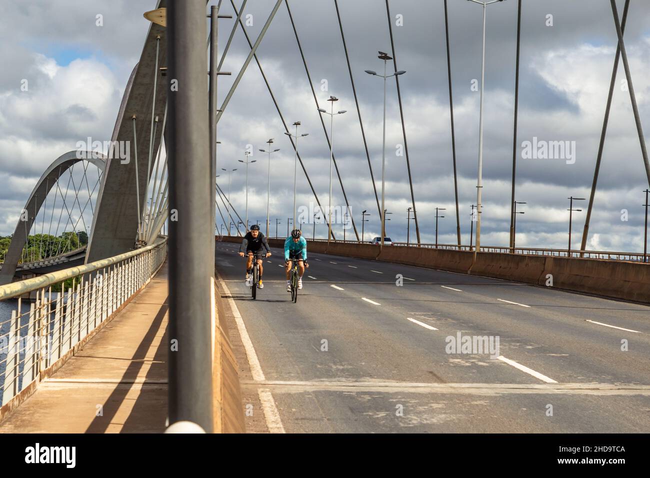 Brasilia, District fédéral, Brésil – 26 décembre 2021 : deux cyclistes traversant le pont JK à Brasília. Banque D'Images