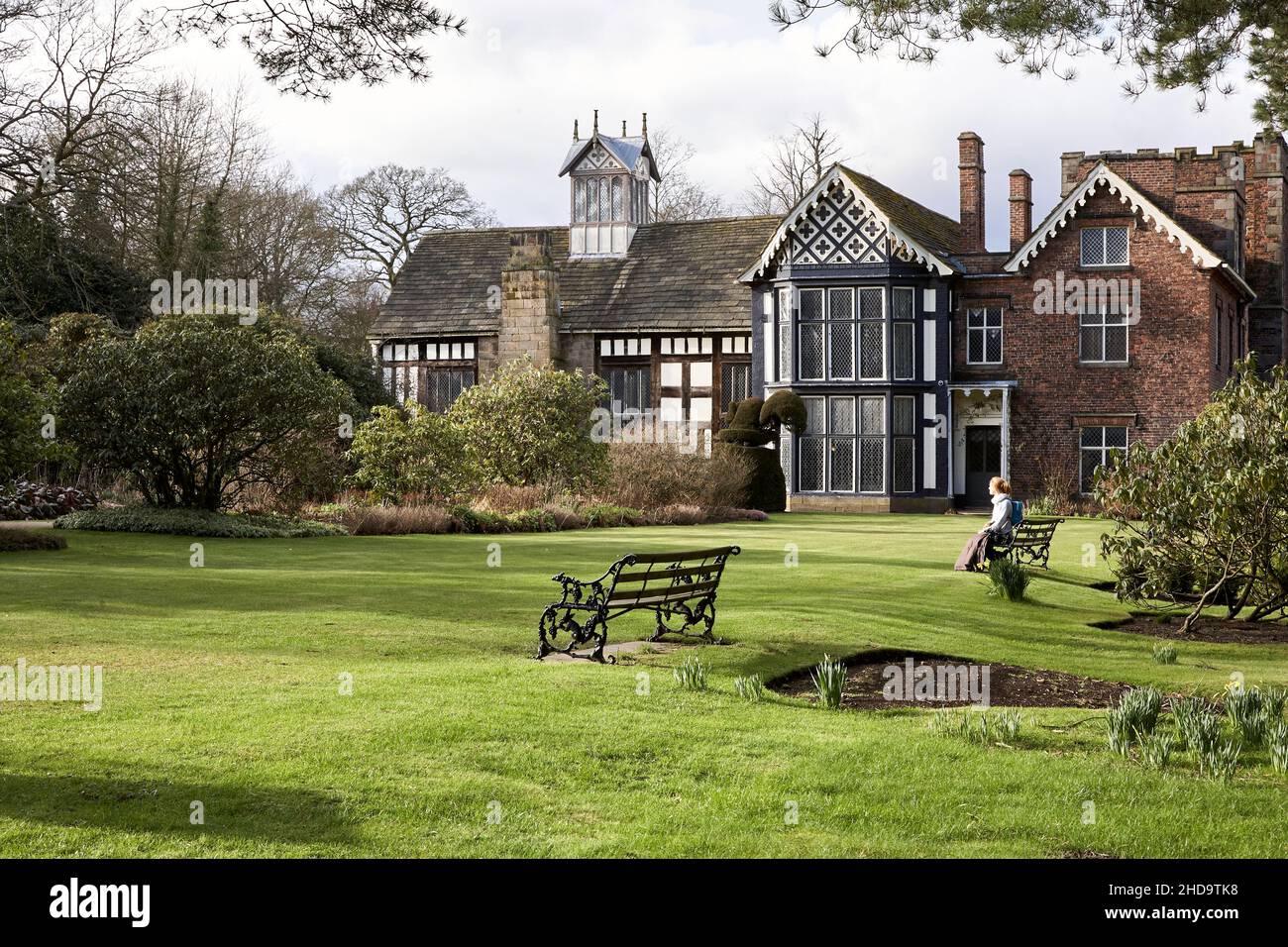 Lady sur le banc en profitant du soleil en soirée dans les jardins du hall de rufford Banque D'Images